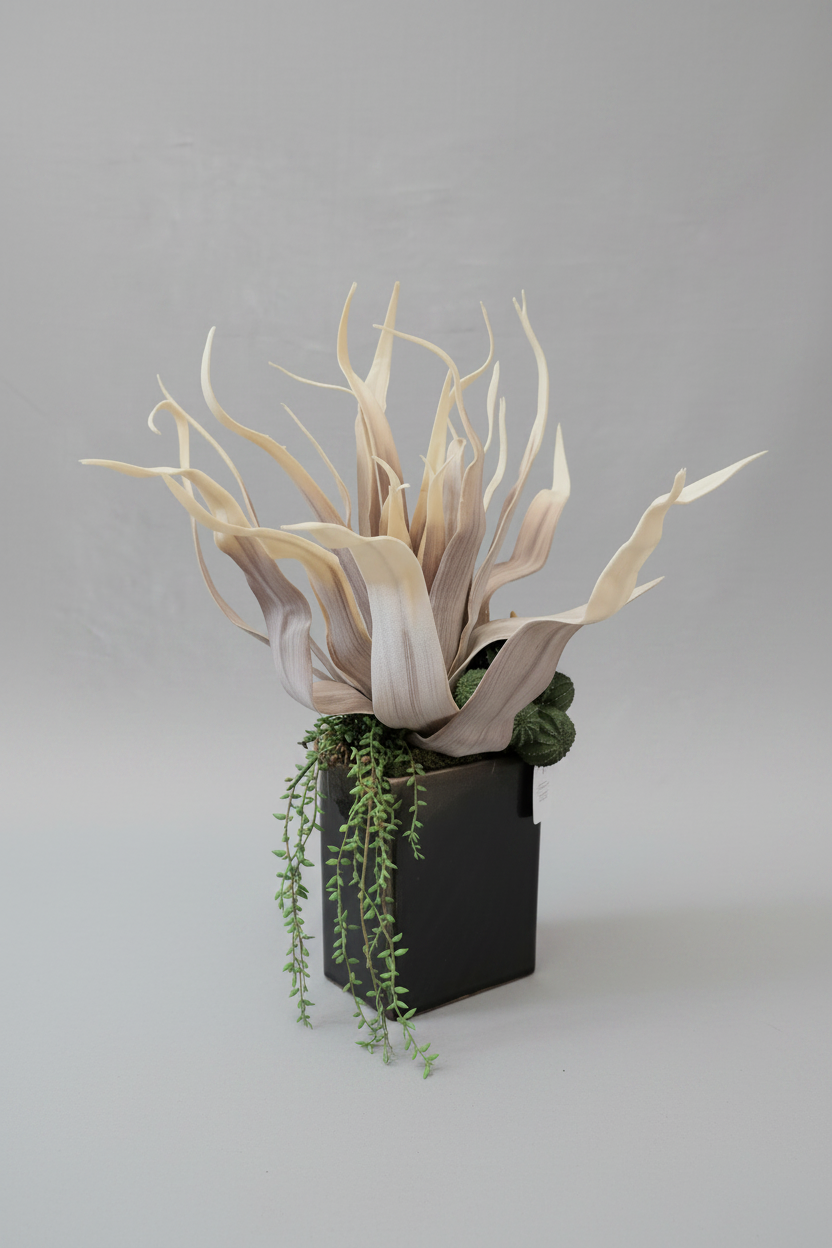 Decorative plant arrangement with dried leaves and a small green plant in a black pot on a gray background