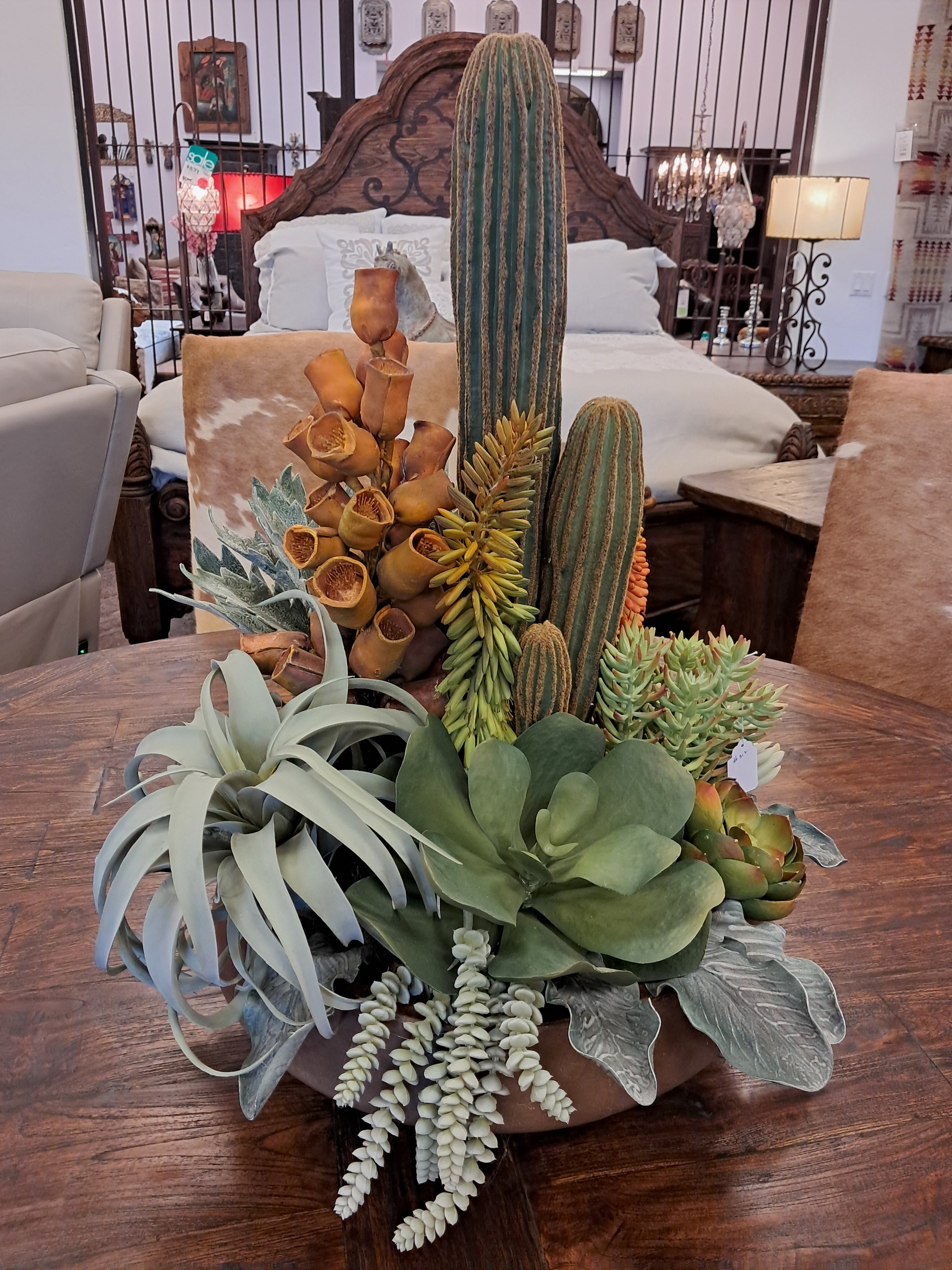 Decorative arrangement of artificial plants on a wooden surface with a blurred indoor background.