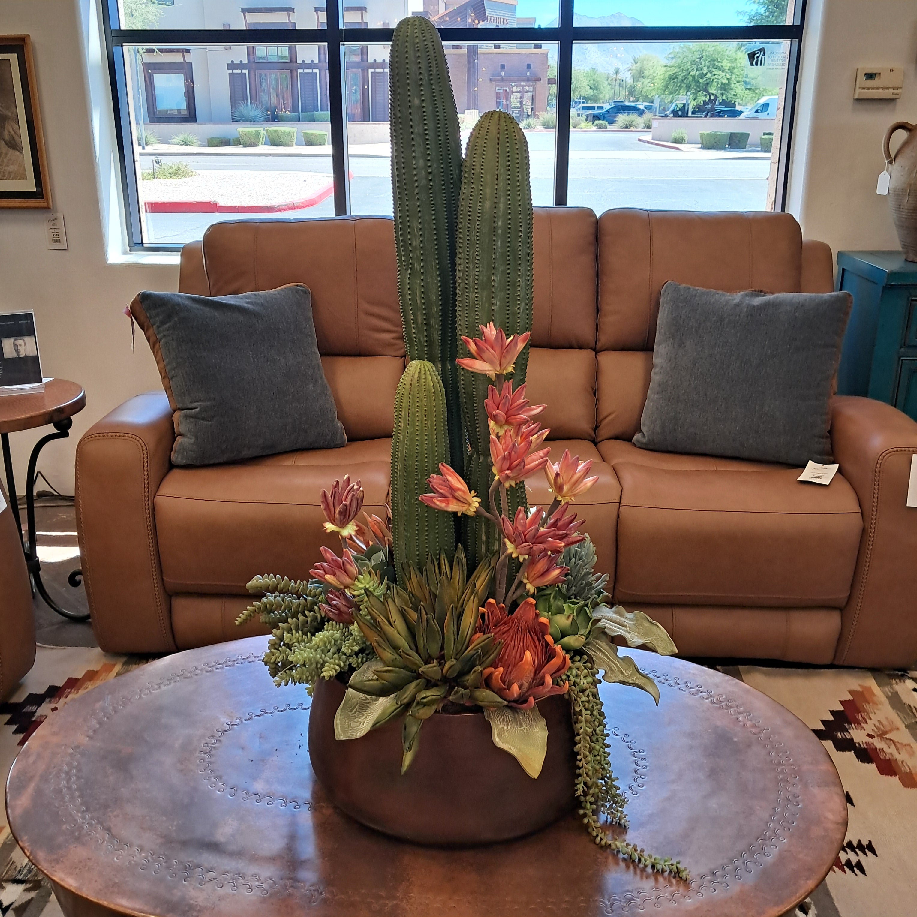 Brown sectional sofa with a decorative cactus plant in a living room setting.