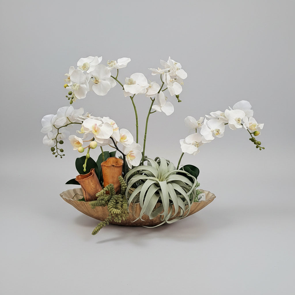 Decorative arrangement of white flowers and green plants on a brown leather sofa.