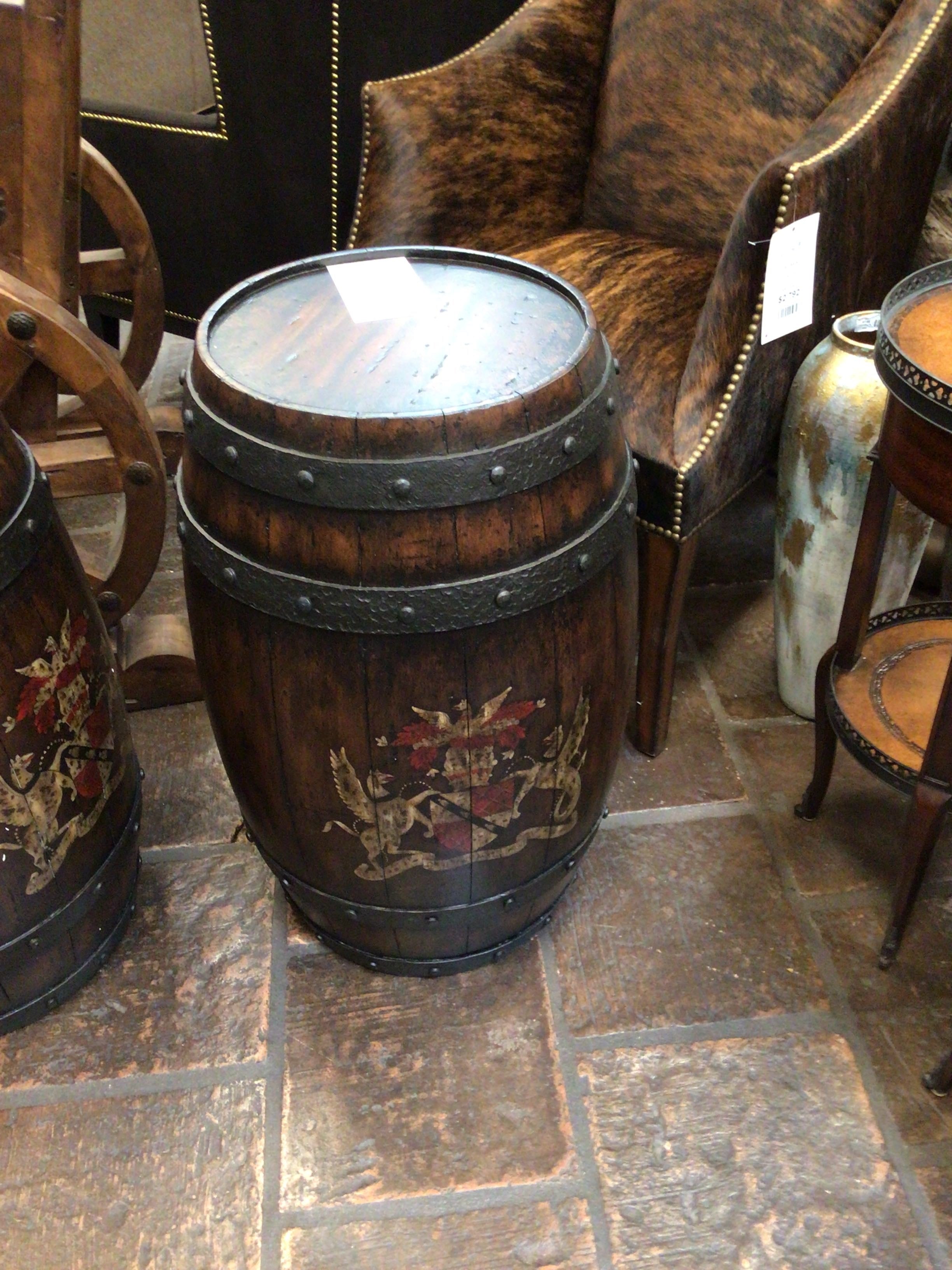 Decorative wooden barrel table with intricate carvings on a stone floor.