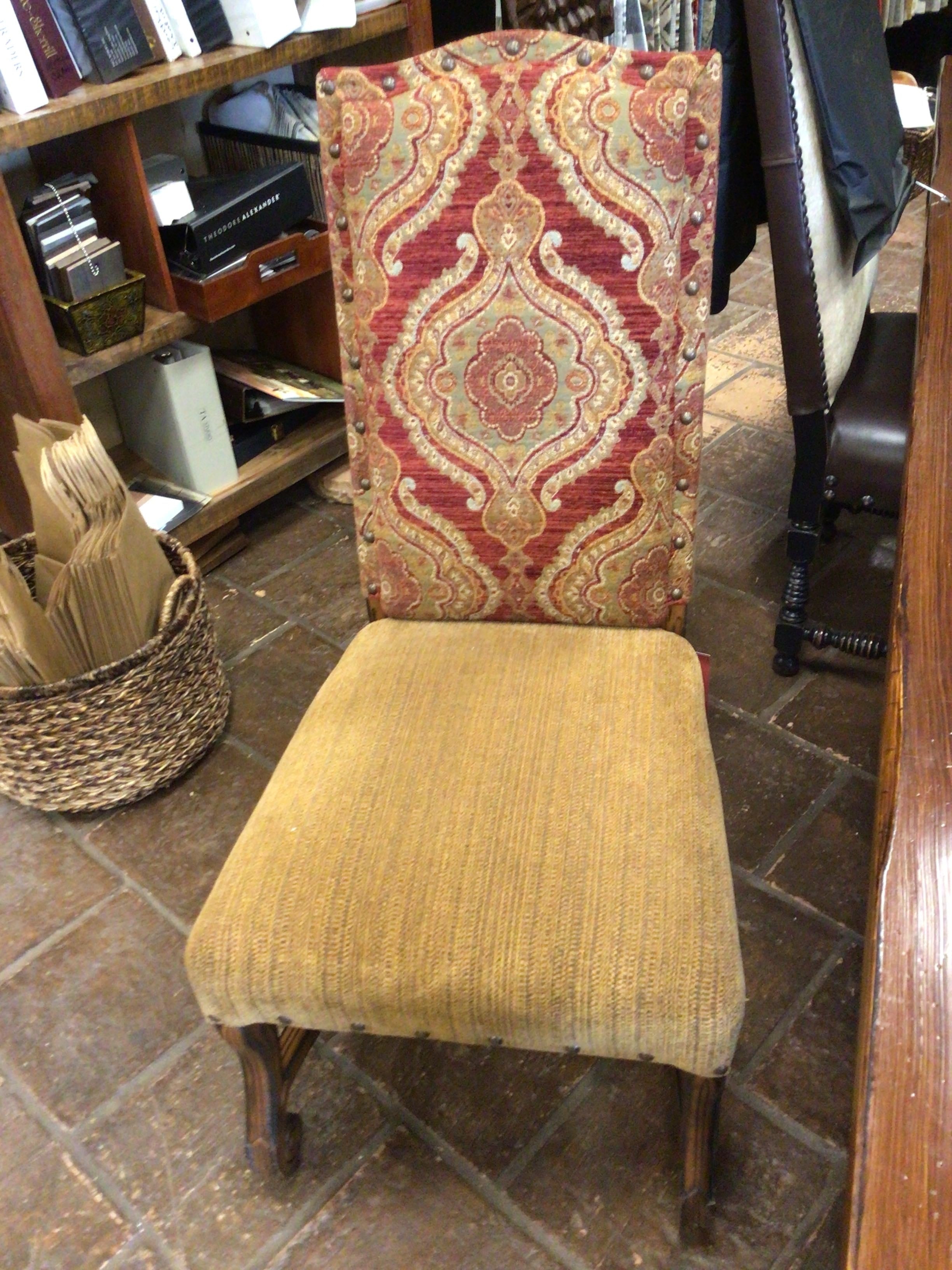 Chair with patterned backrest and beige seat on a stone floor