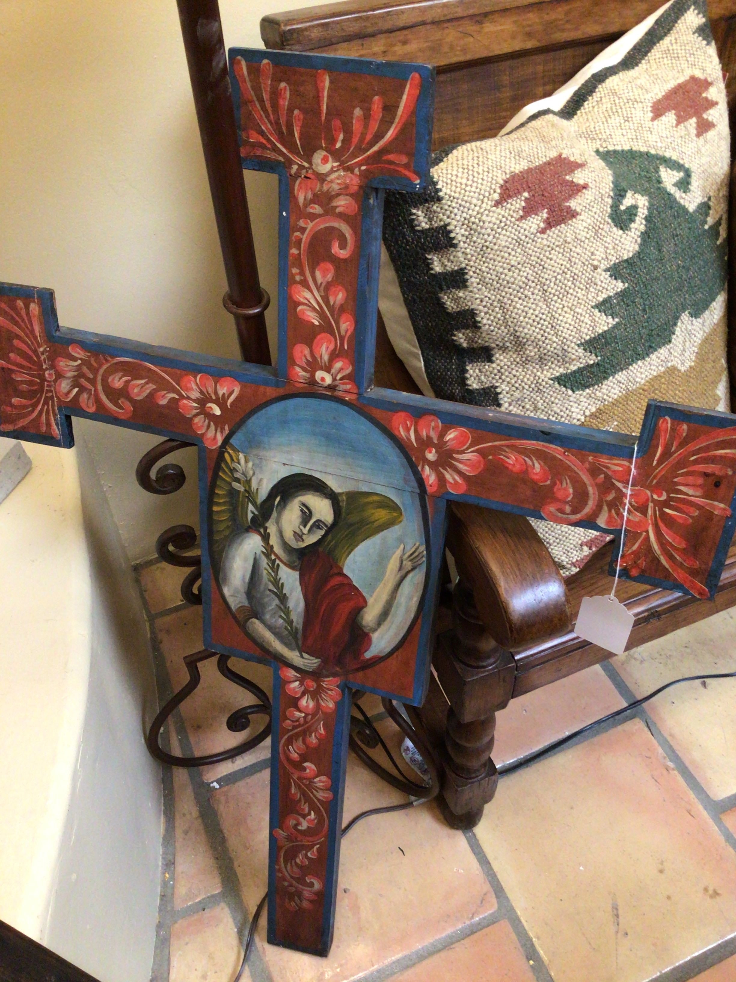 Decorative cross with religious iconography on a wooden surface