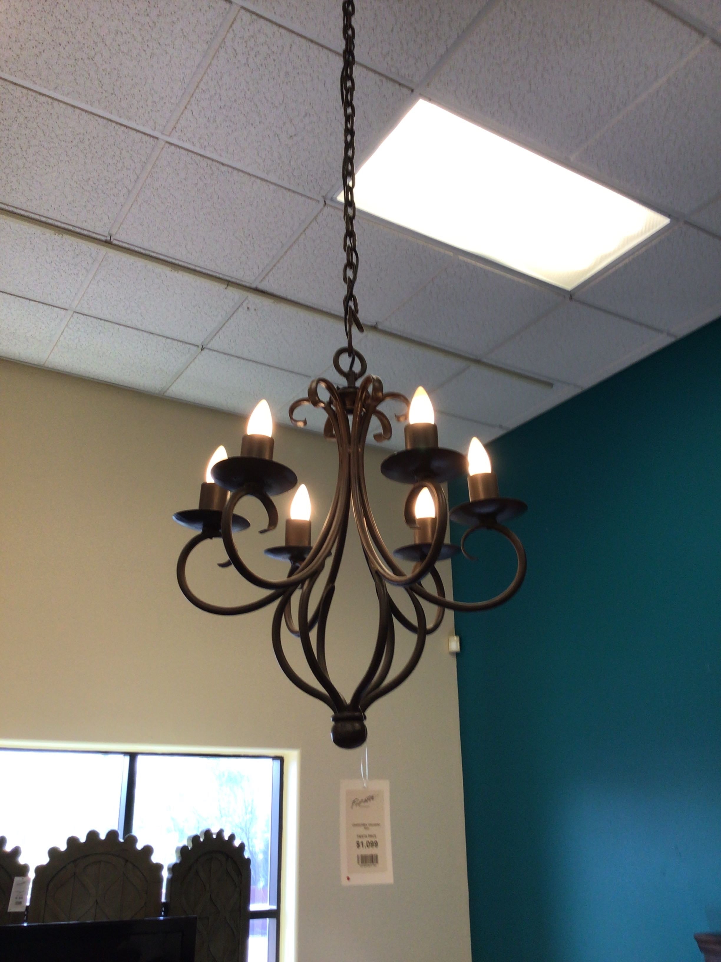 Decorative chandelier hanging from a ceiling with a light fixture above it.
