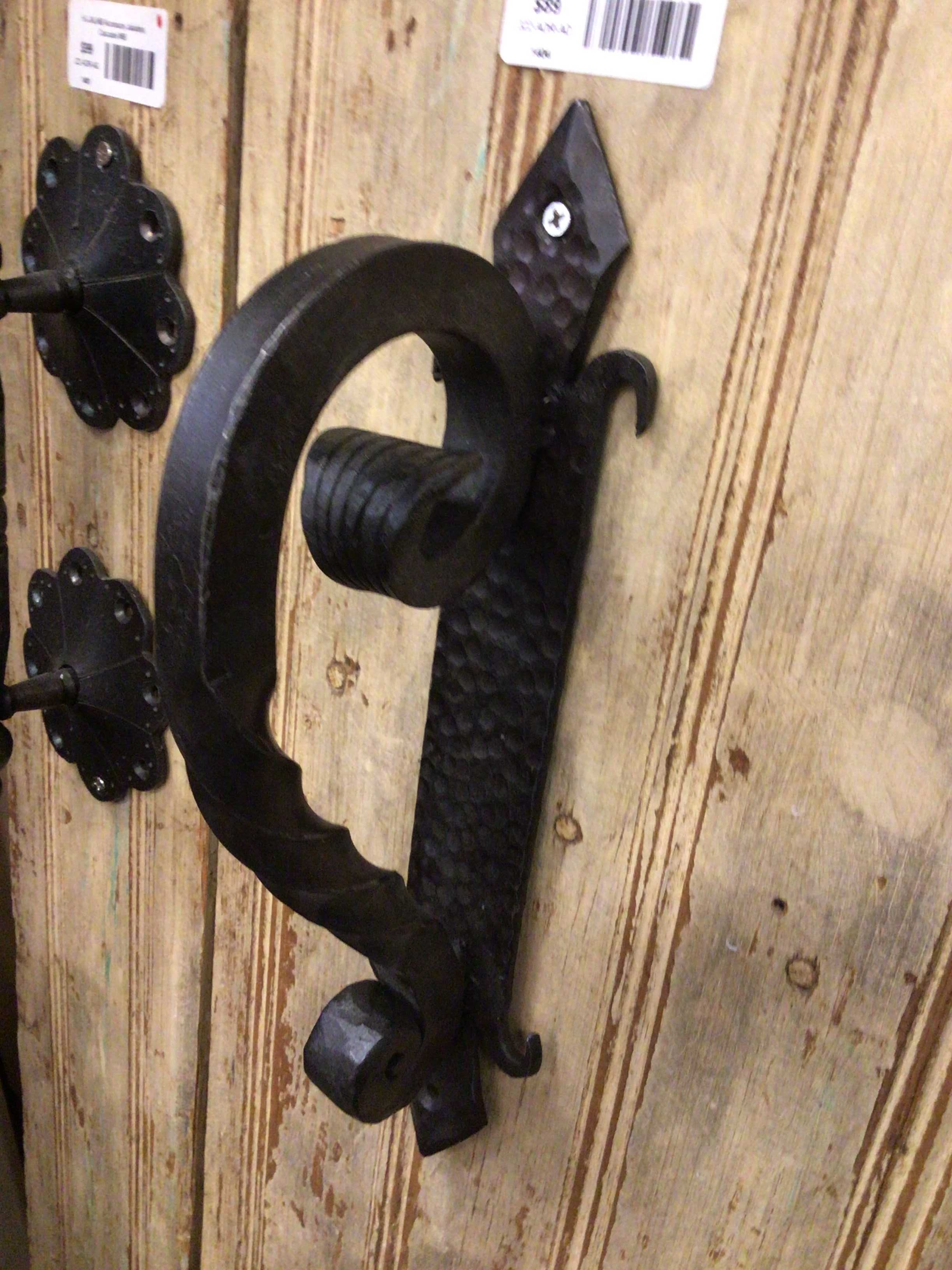 Black metal wall hook on a wooden surface