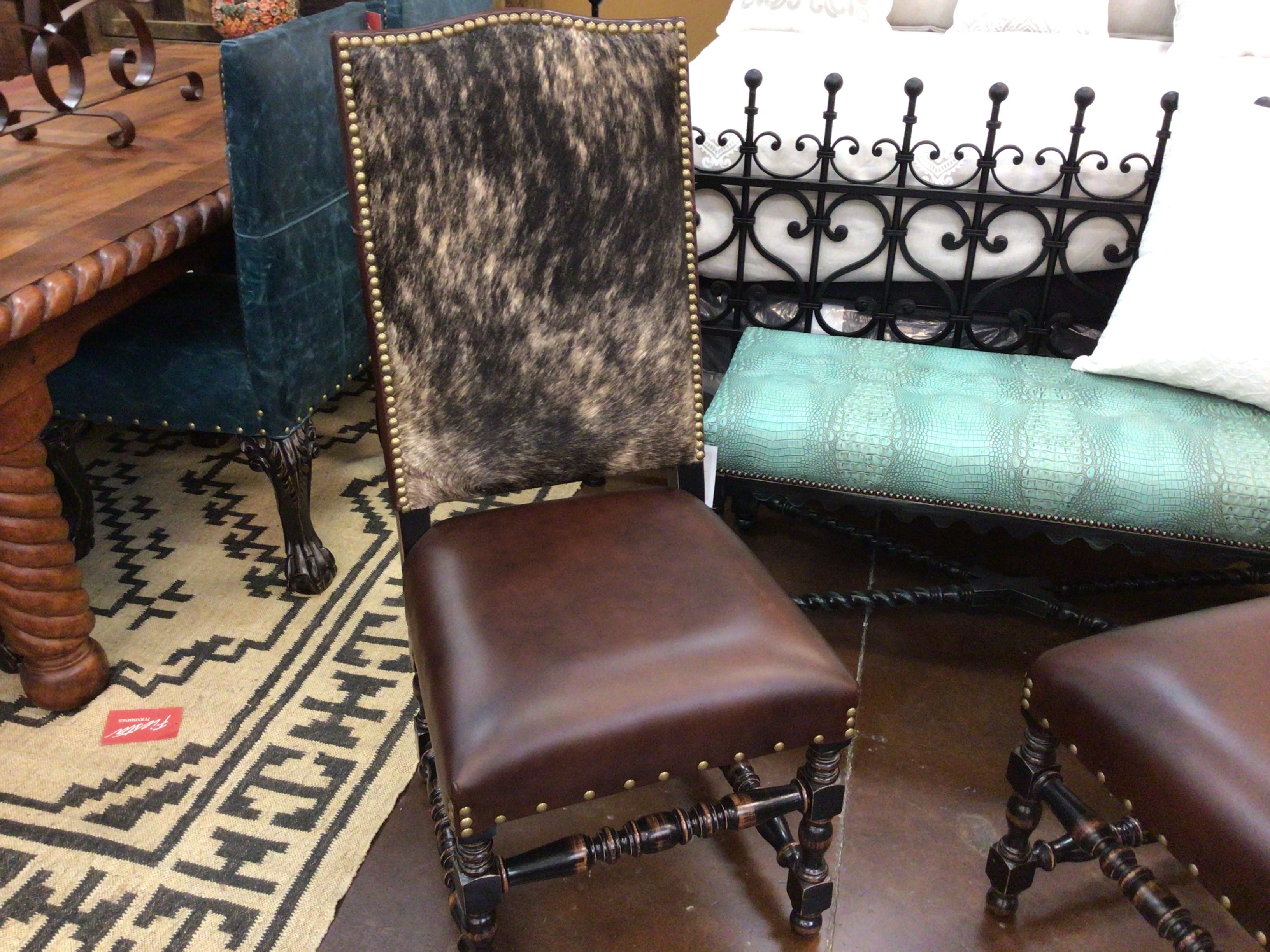 Brown leather chair with decorative backrest in a room with furniture and decor.