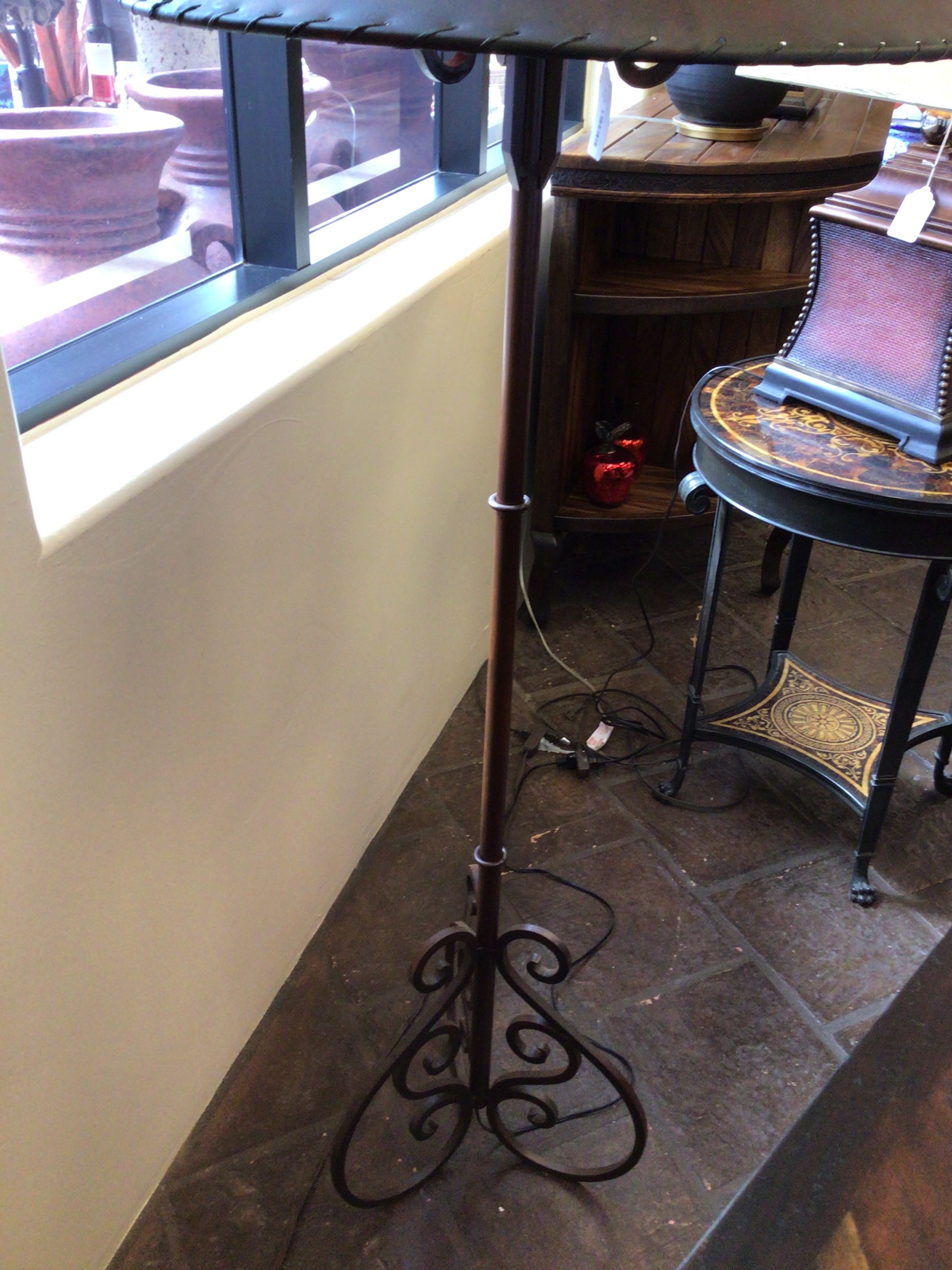 Decorative metal table with intricate design on a tiled floor.