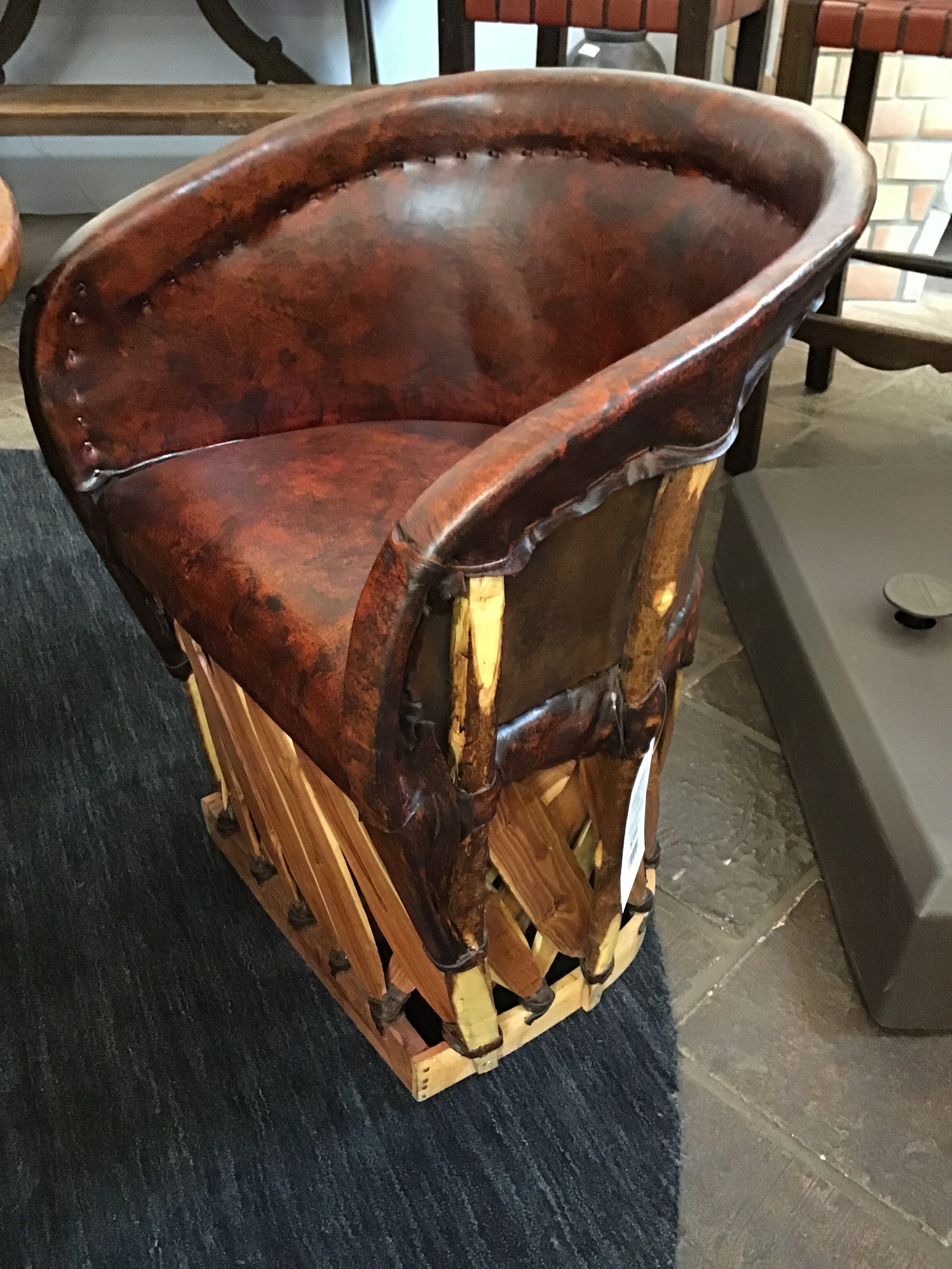 Brown leather chair with wooden frame on a dark surface