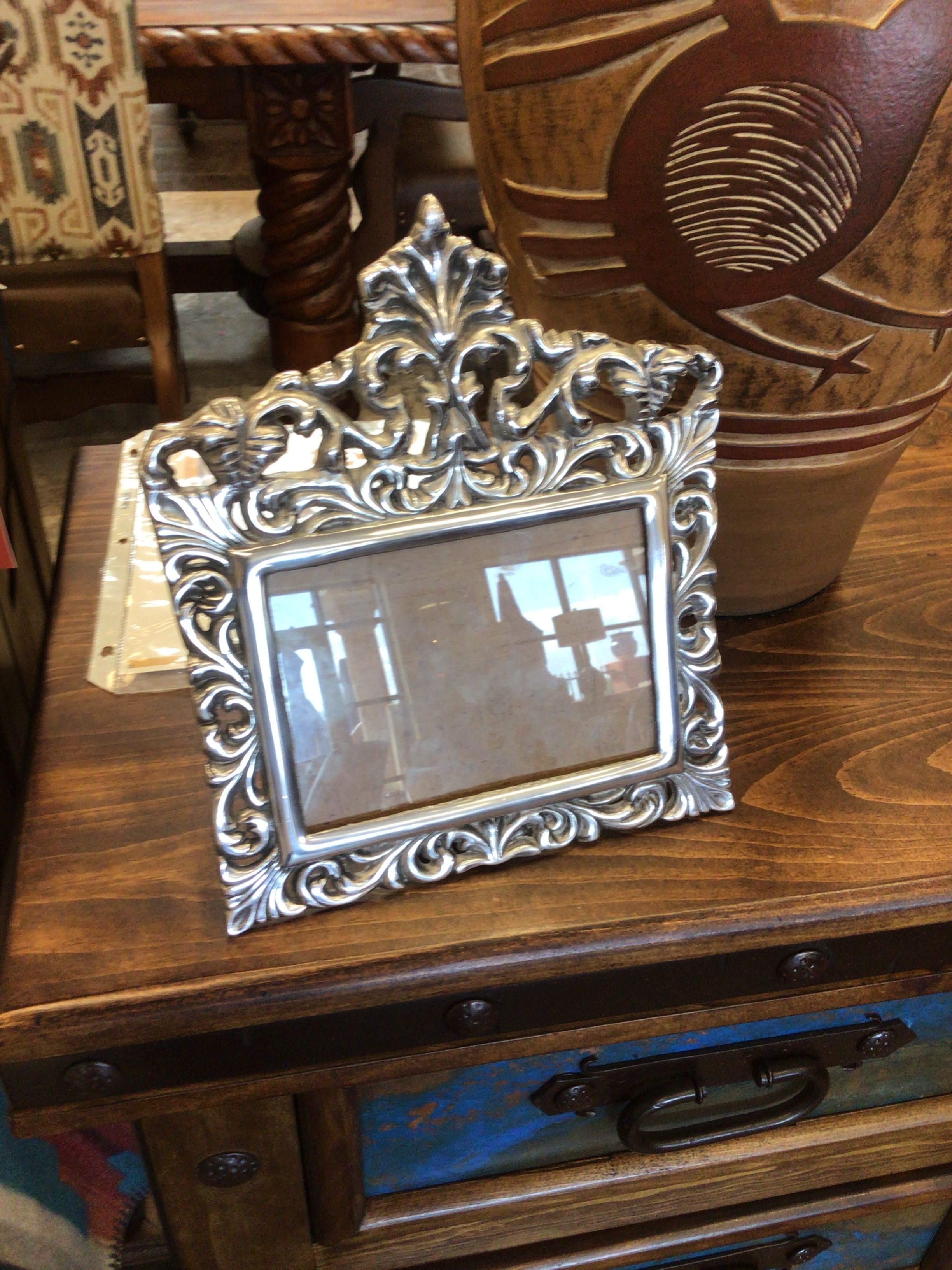 Decorative silver frame on a wooden surface with a blurred background