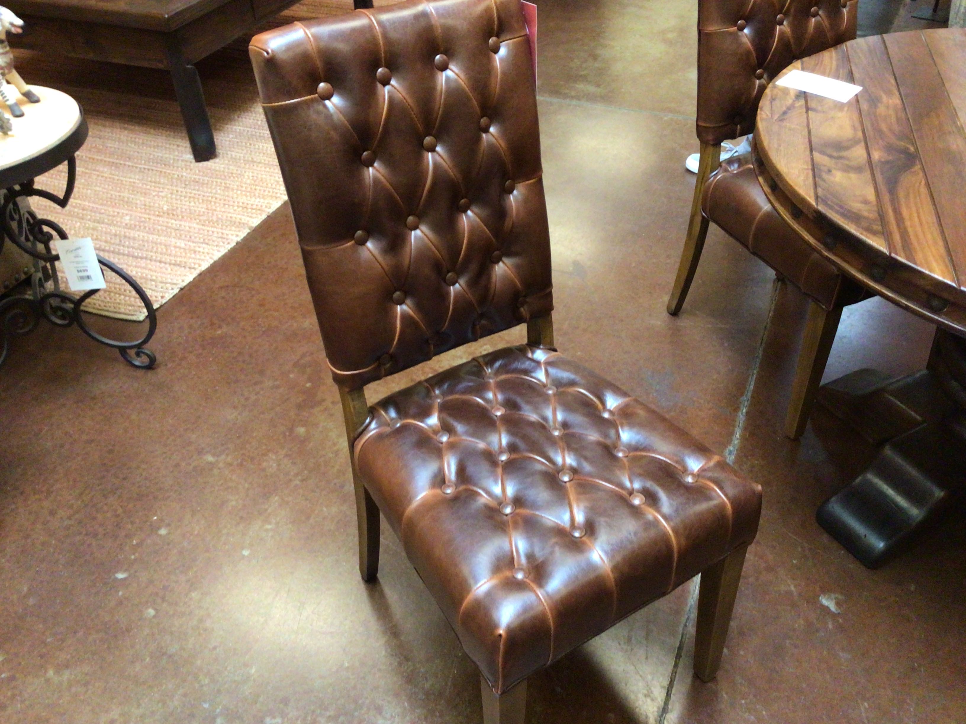 Brown leather chair with tufted backrest in a room setting