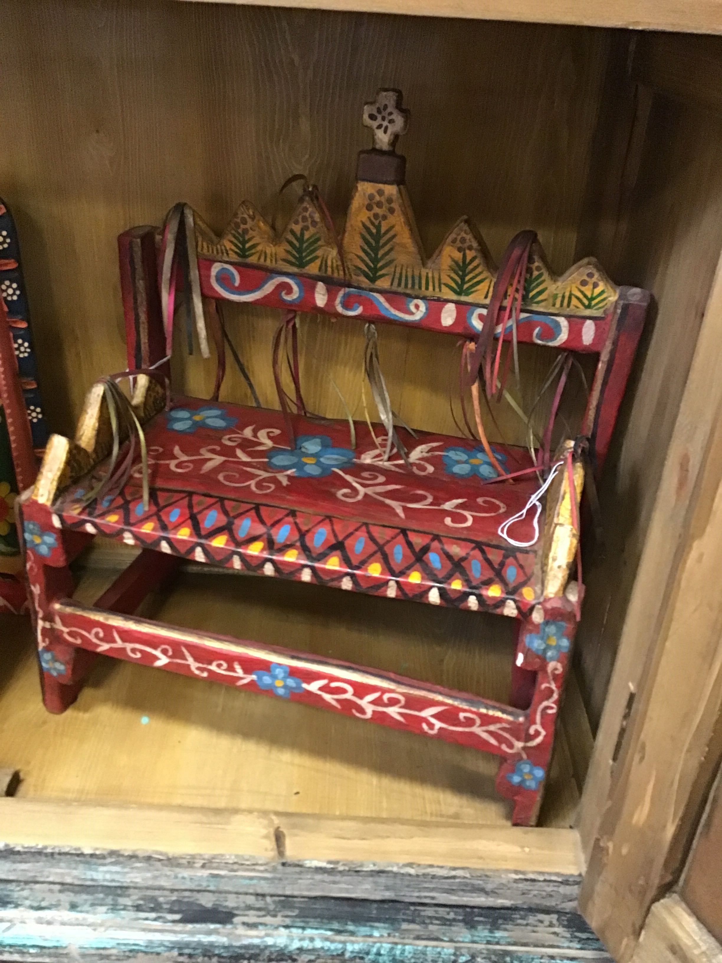 Decorative bench with floral patterns on a wooden surface in a store setting