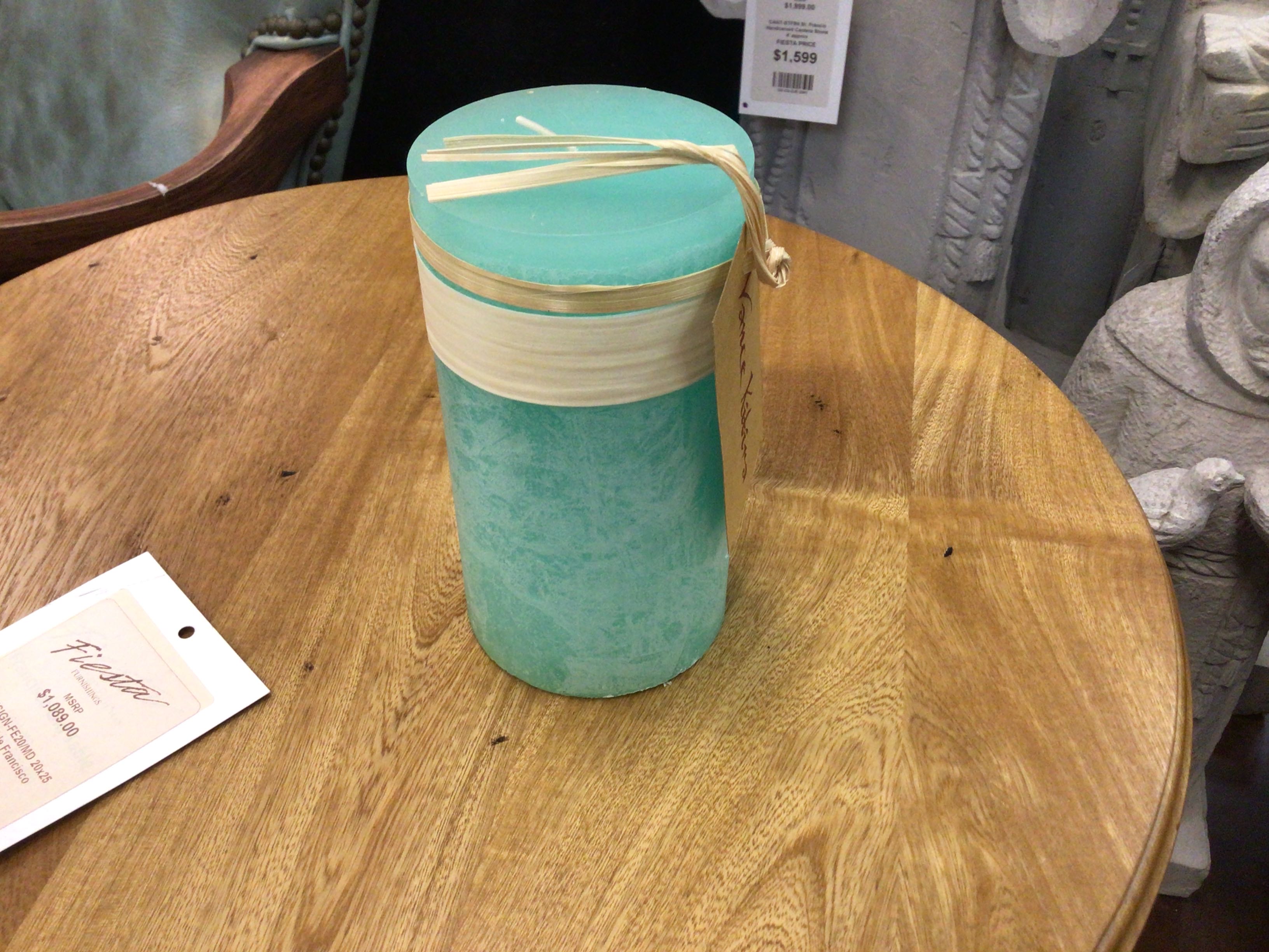 Turquoise container with a beige lid on a wooden table