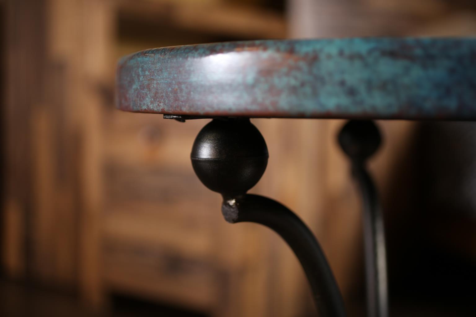 Close-up of a vintage chair with a worn wooden seat and metal legs against a blurred wooden background.
