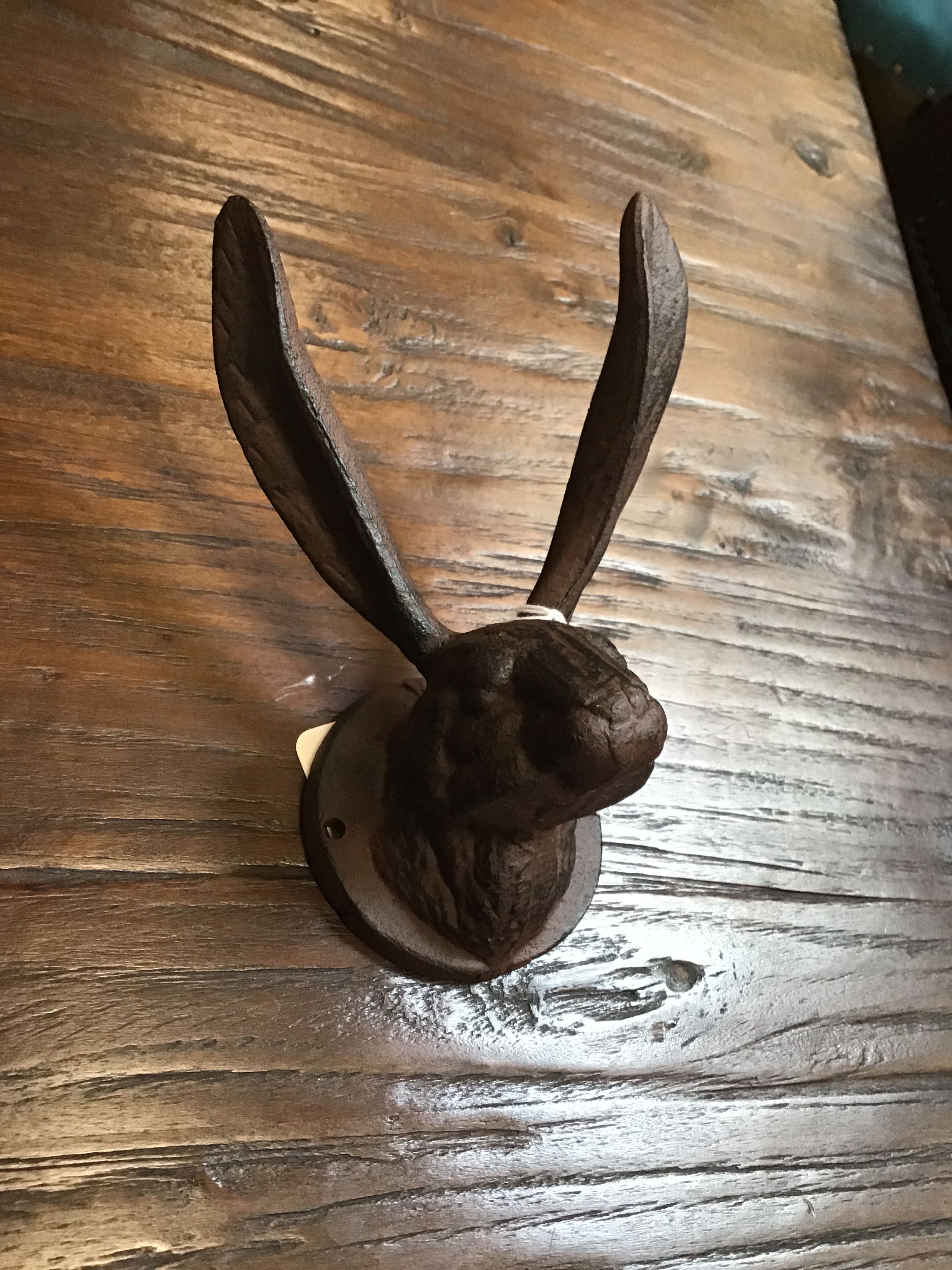 Decorative wall hook shaped like a rabbit on a wooden surface