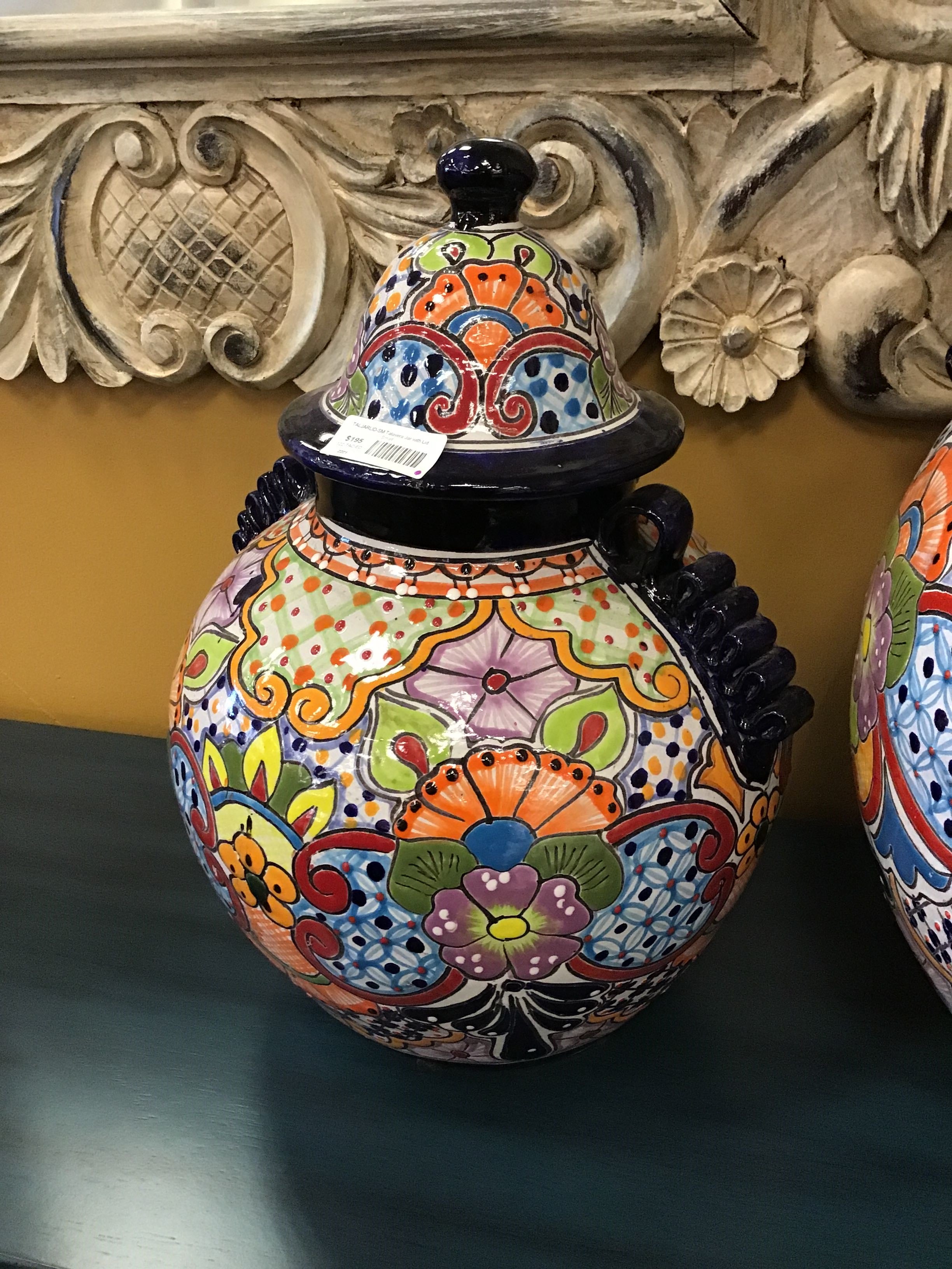 Decorative colorful vase with intricate patterns on a reflective surface.