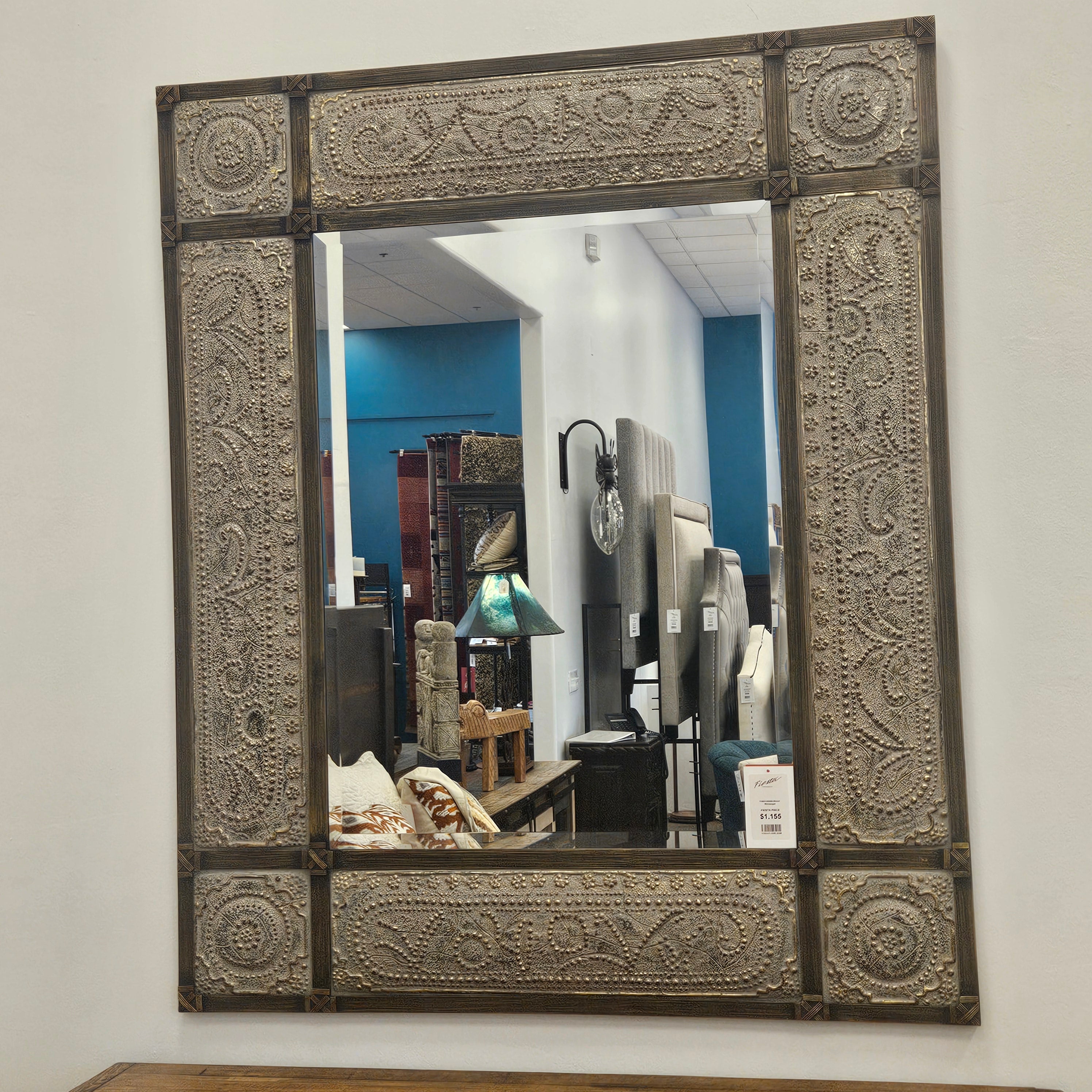 Decorative mirror with intricate patterns on a white wall