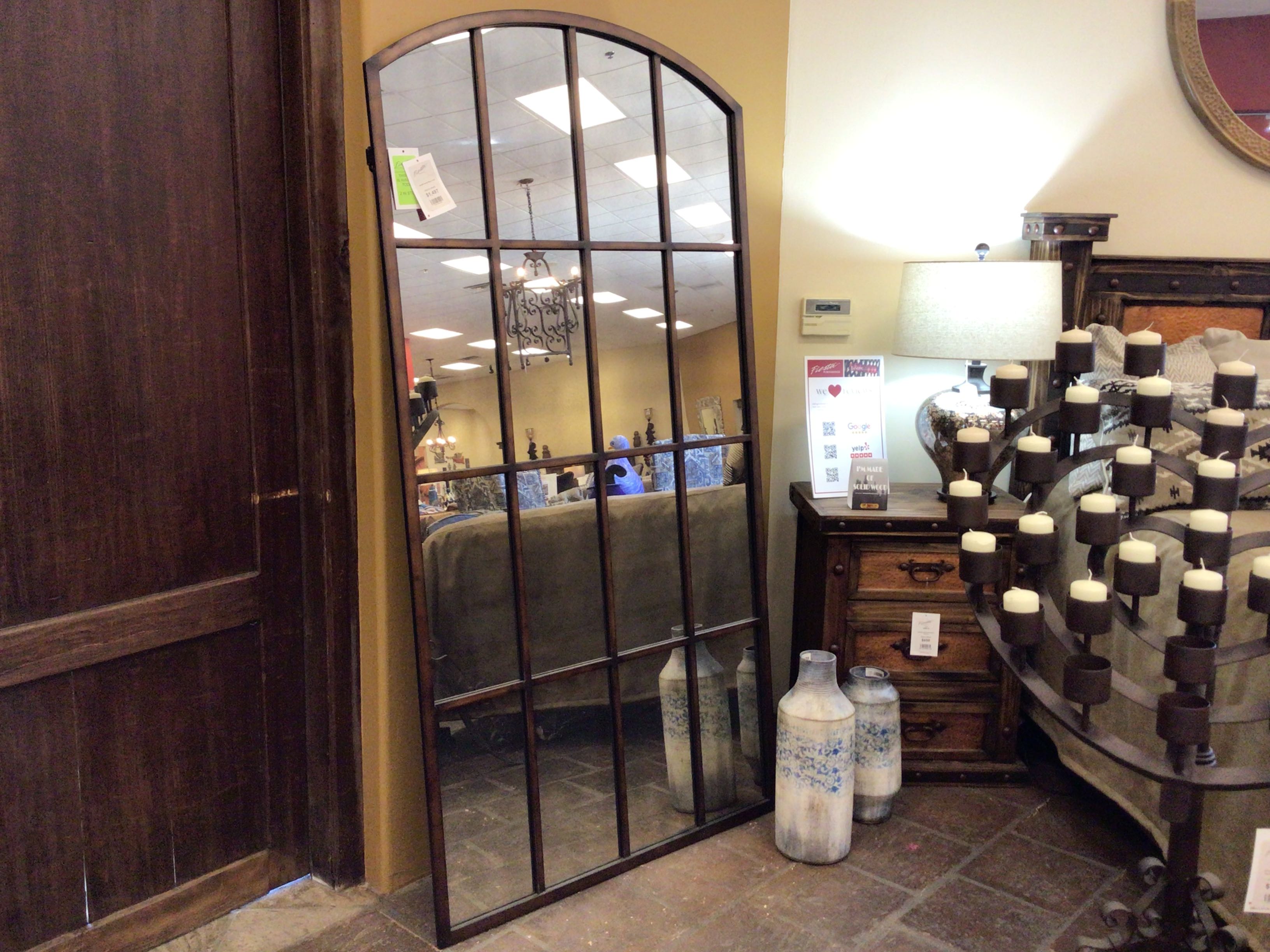 Large decorative mirror with metal frame in a store setting