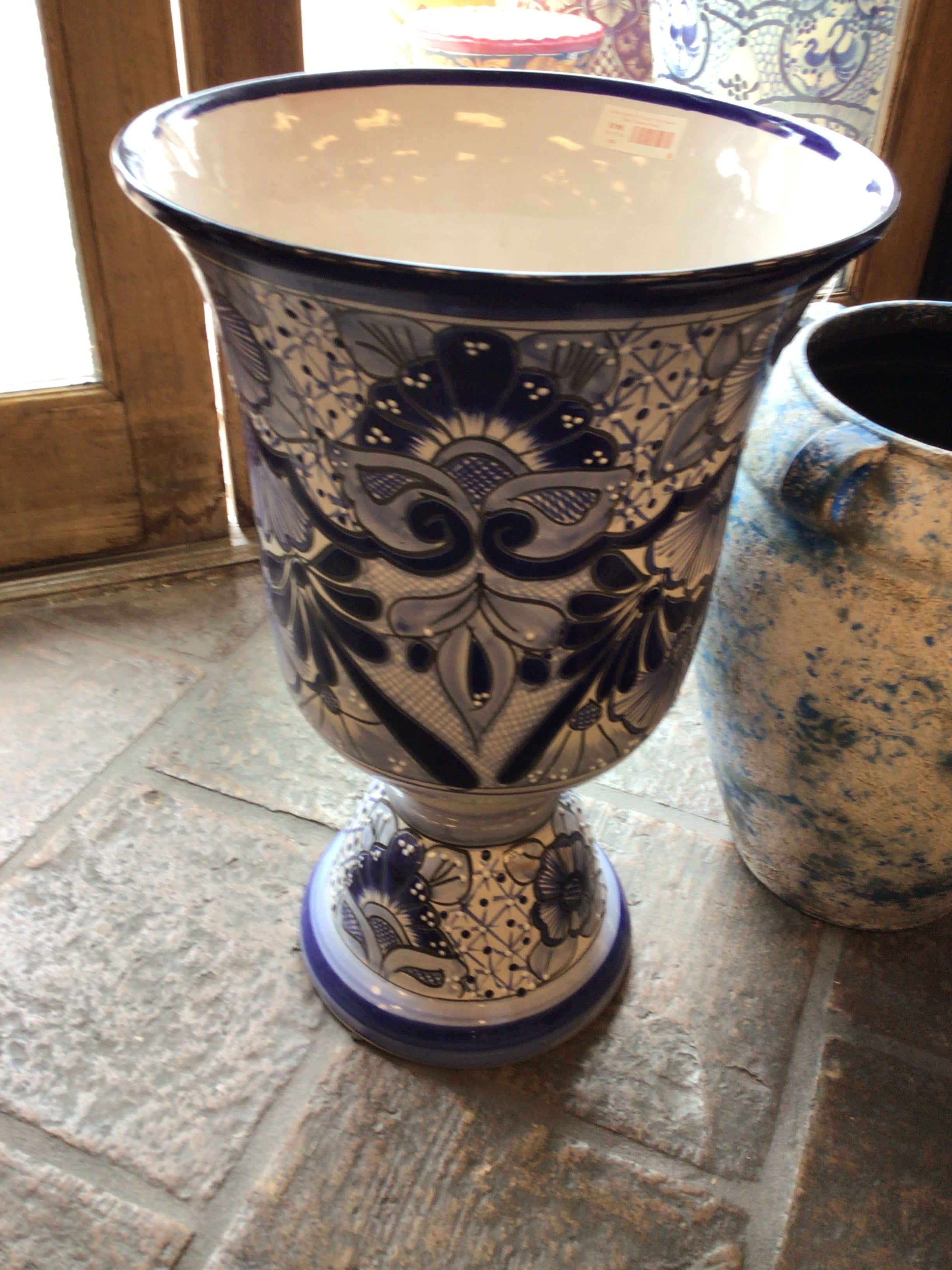 Decorative ceramic vase with blue and white patterns on a stone surface.