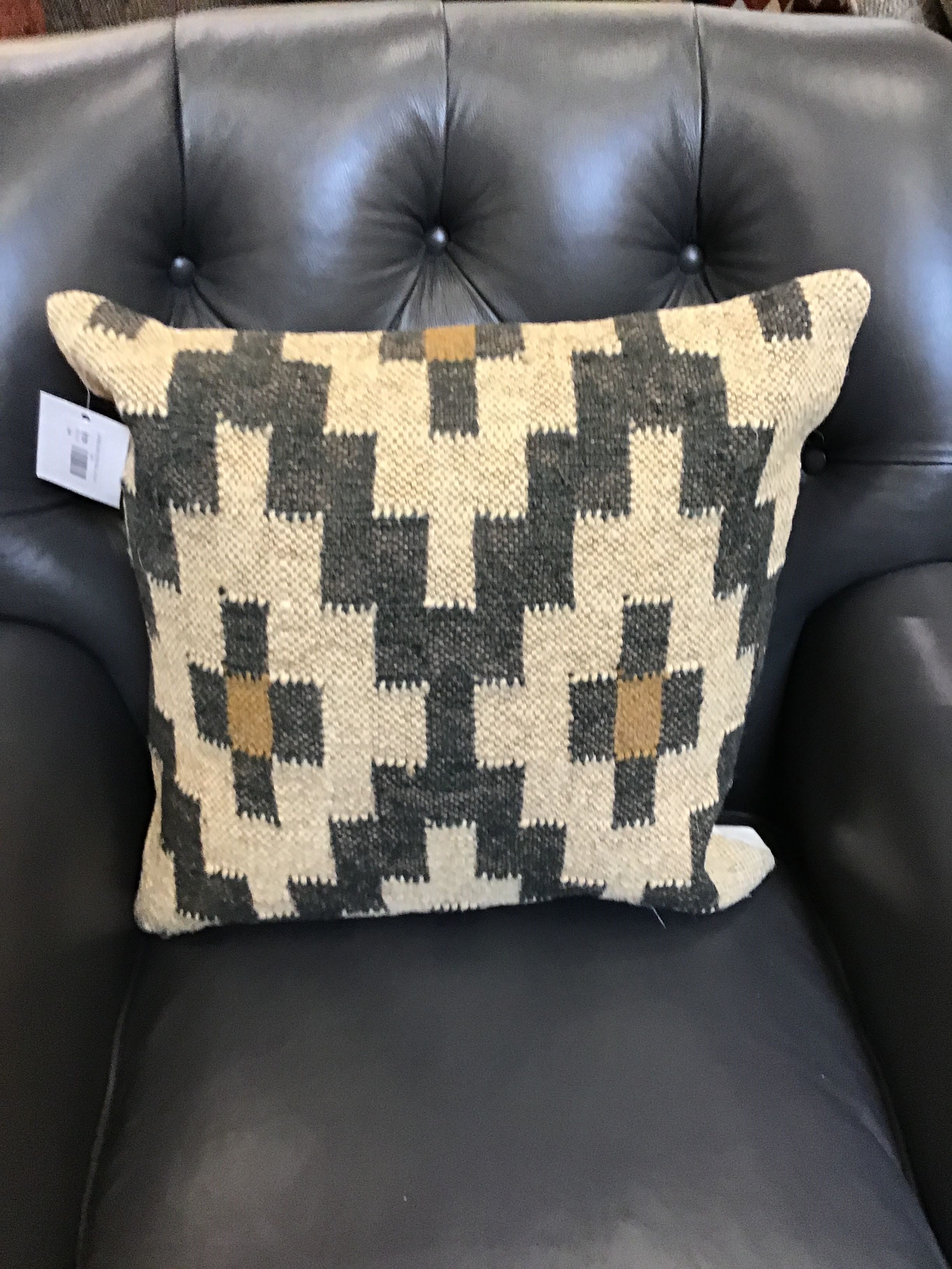 Decorative pillow with geometric pattern on a black leather chair