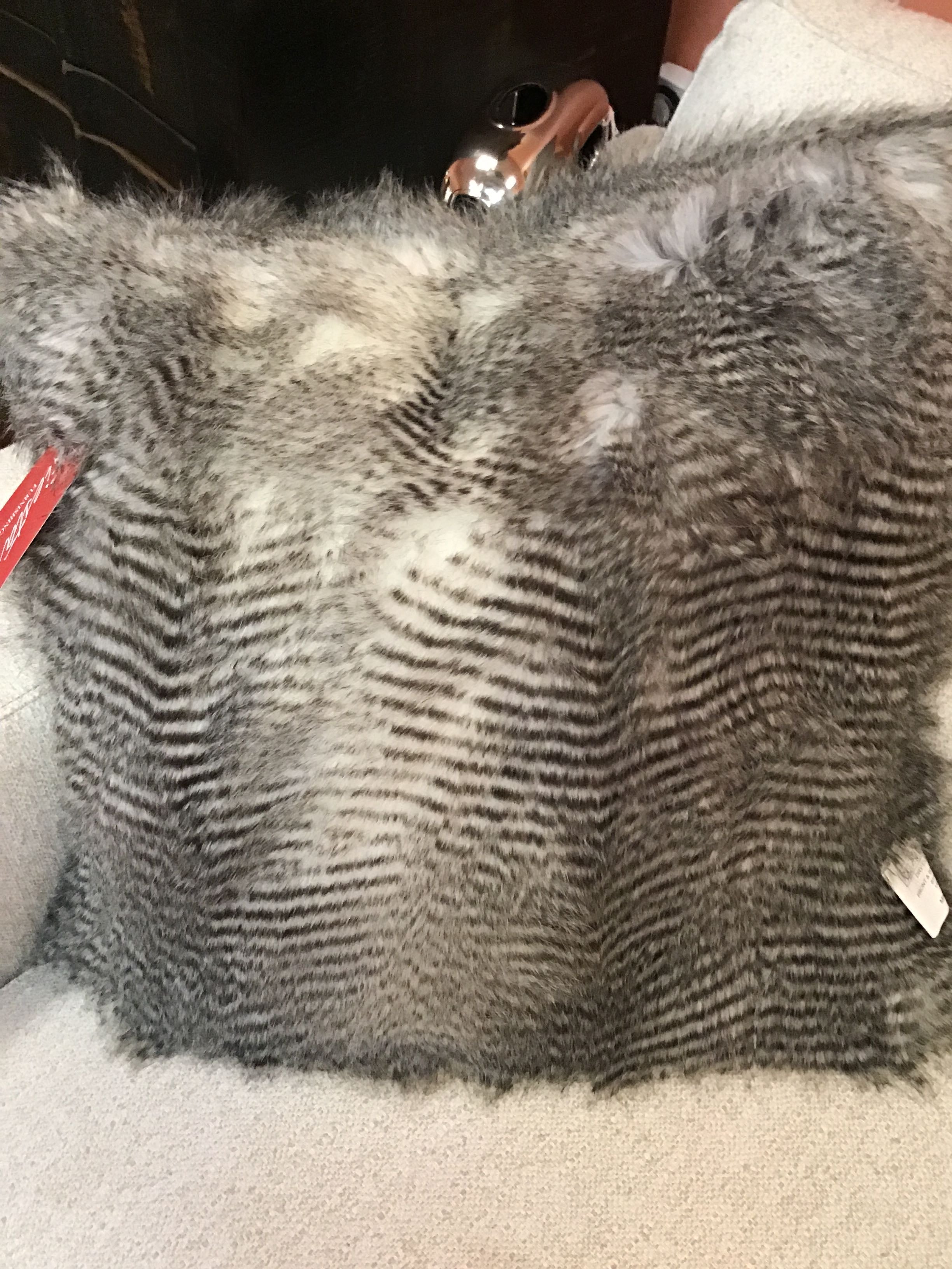 Gray fur-like fabric with a textured pattern on a white surface.