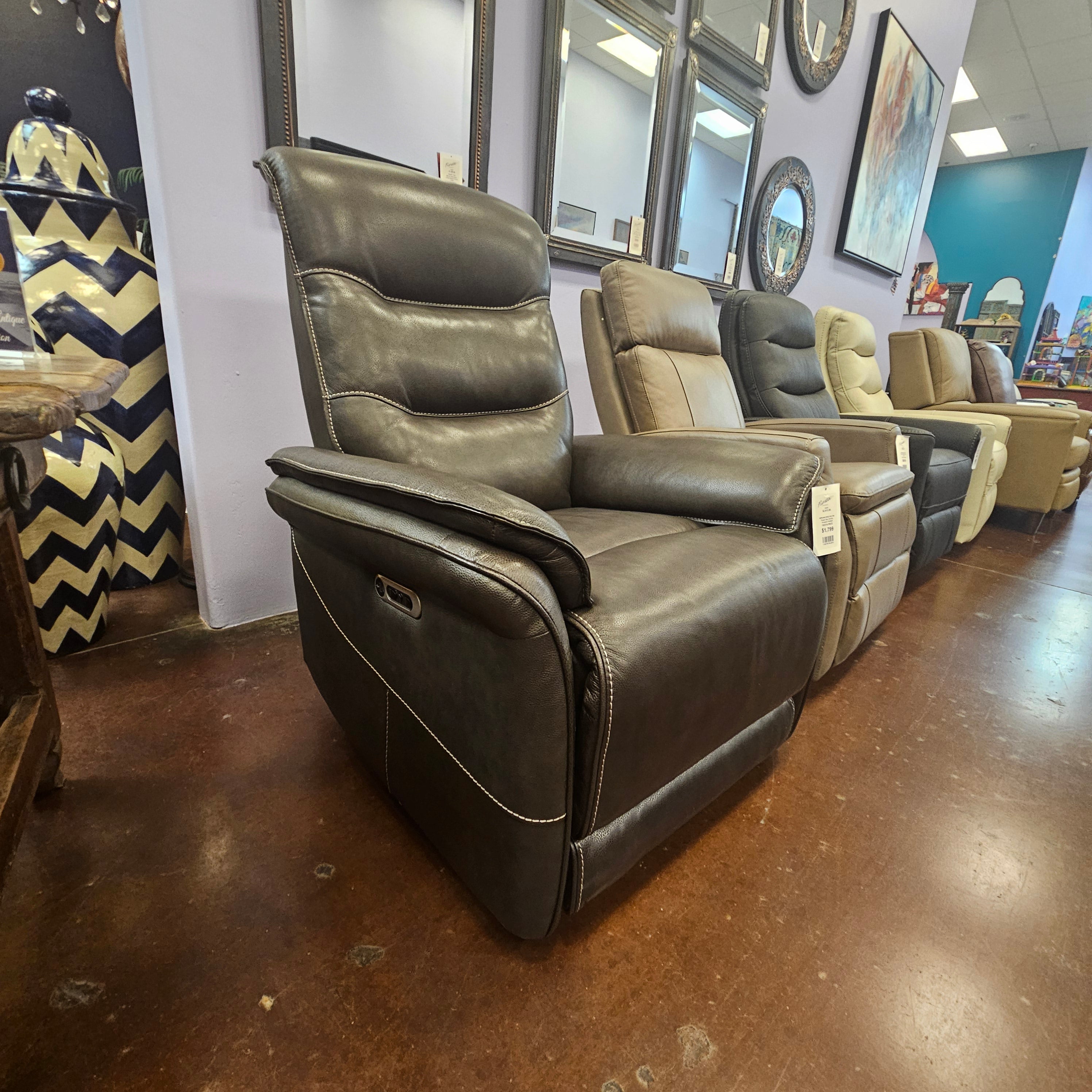 Brown leather recliner sofa in a showroom setting with mirrors and decor.