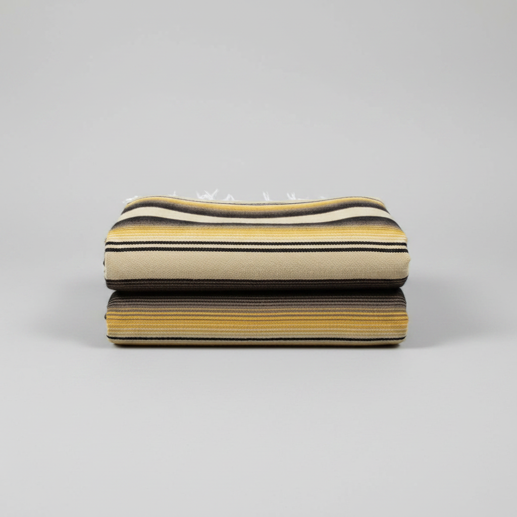 Two folded woven textiles stacked on a light gray background, featuring horizontal stripes in beige, black, and mustard yellow.