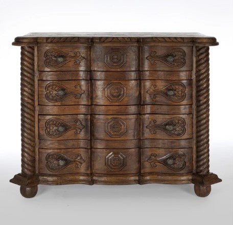 Wooden dresser with intricate carvings on a white background