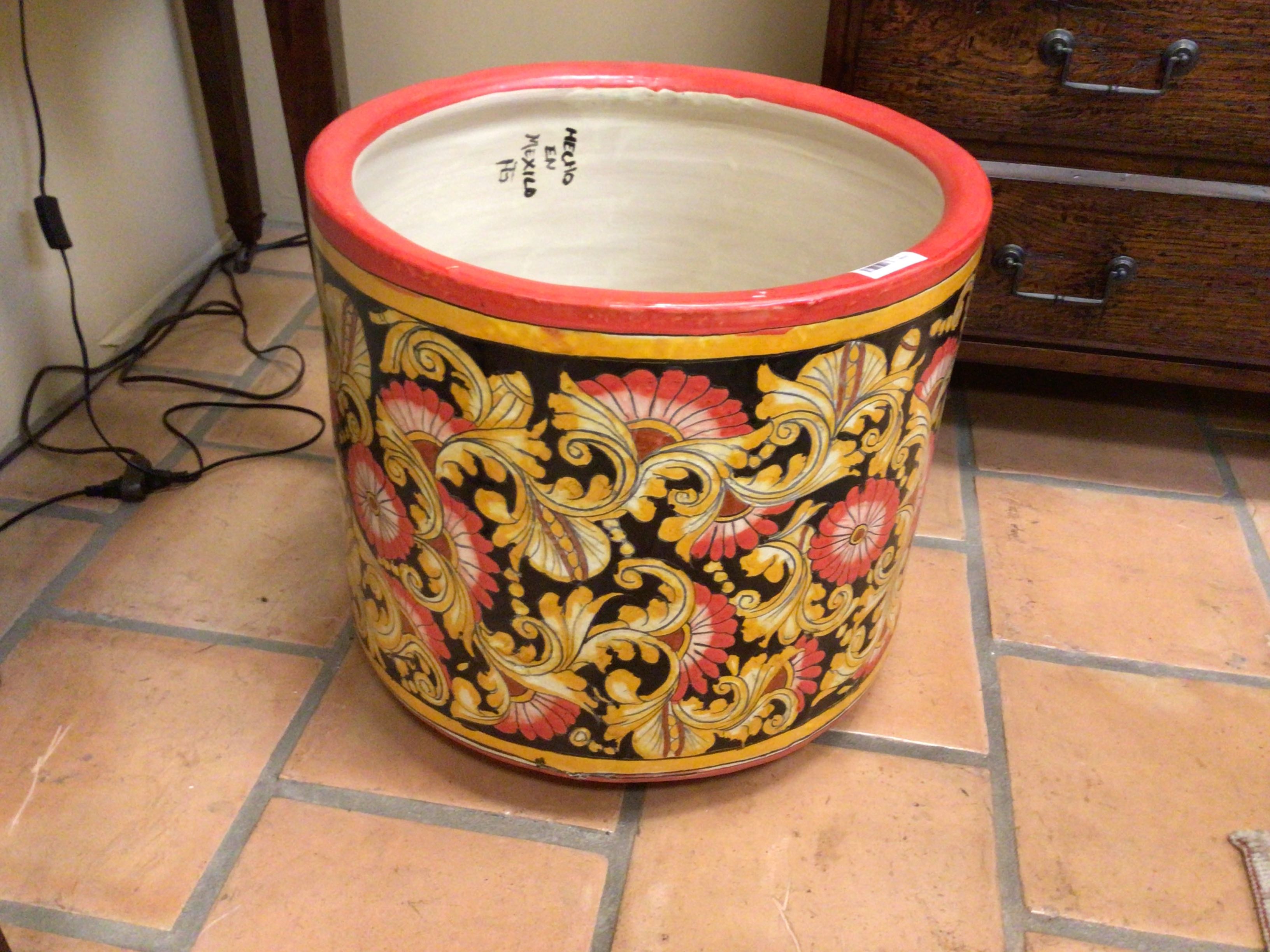 Decorative pot with floral patterns on a tiled floor