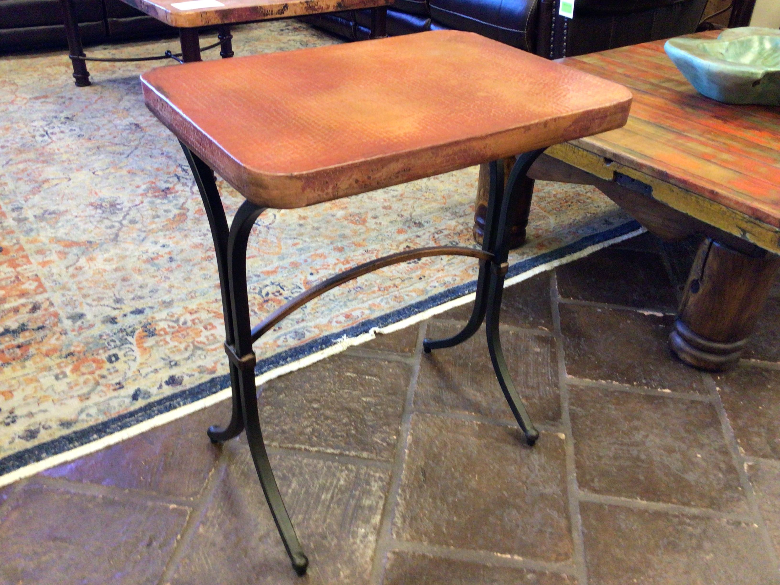 rectangle copper end table with metal legs on a stone floor