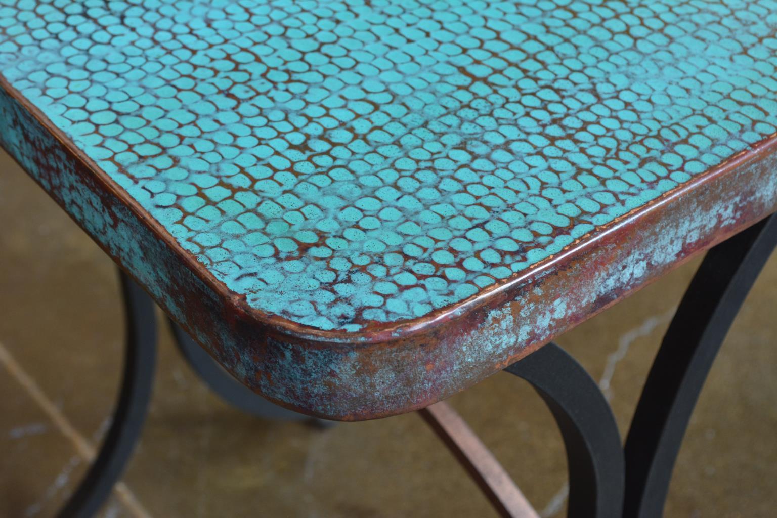 Close-up of a turquoise metal surface with a textured finish on a blurred background
