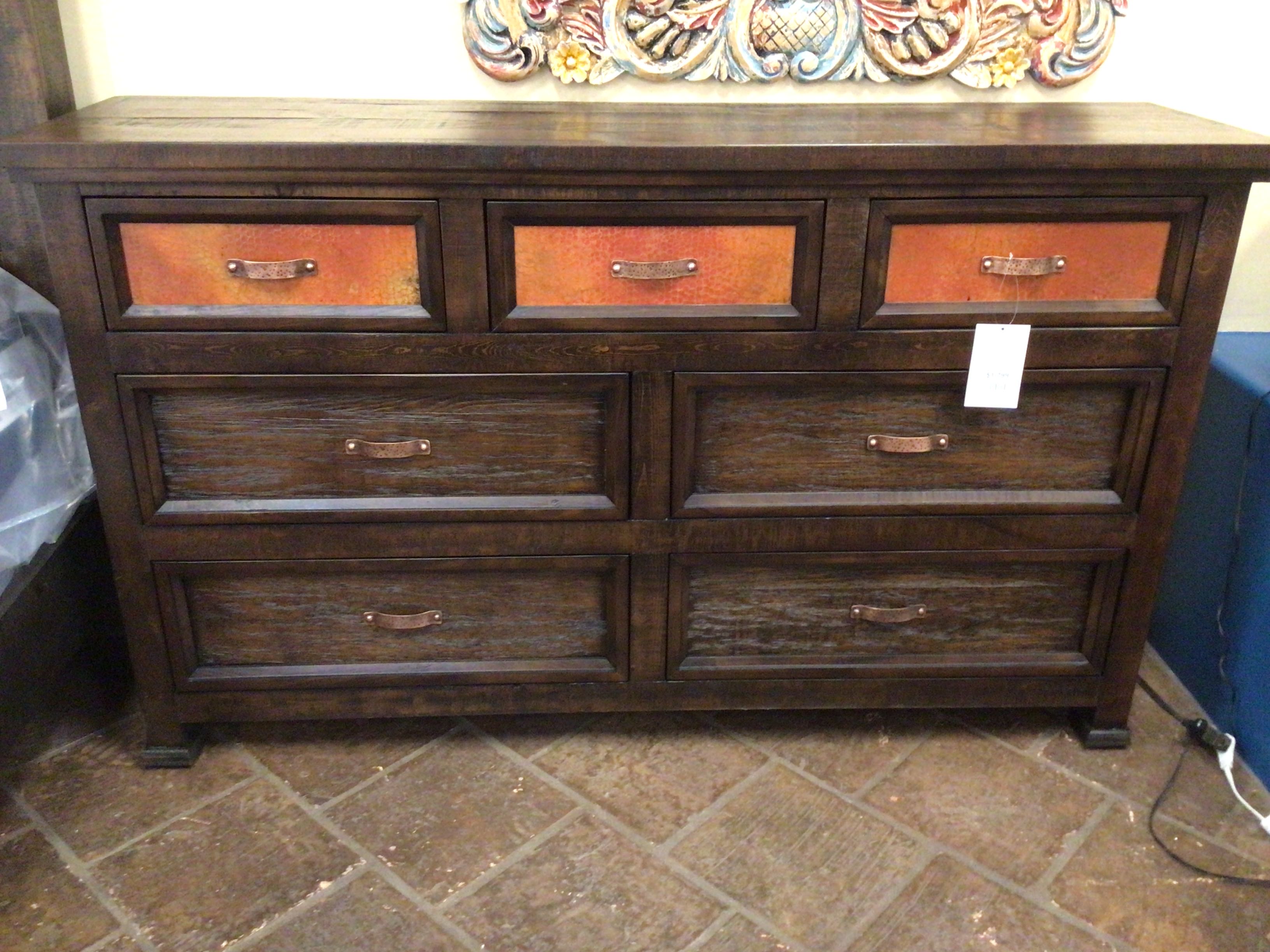 Wooden dresser with multiple drawers on a tiled floor