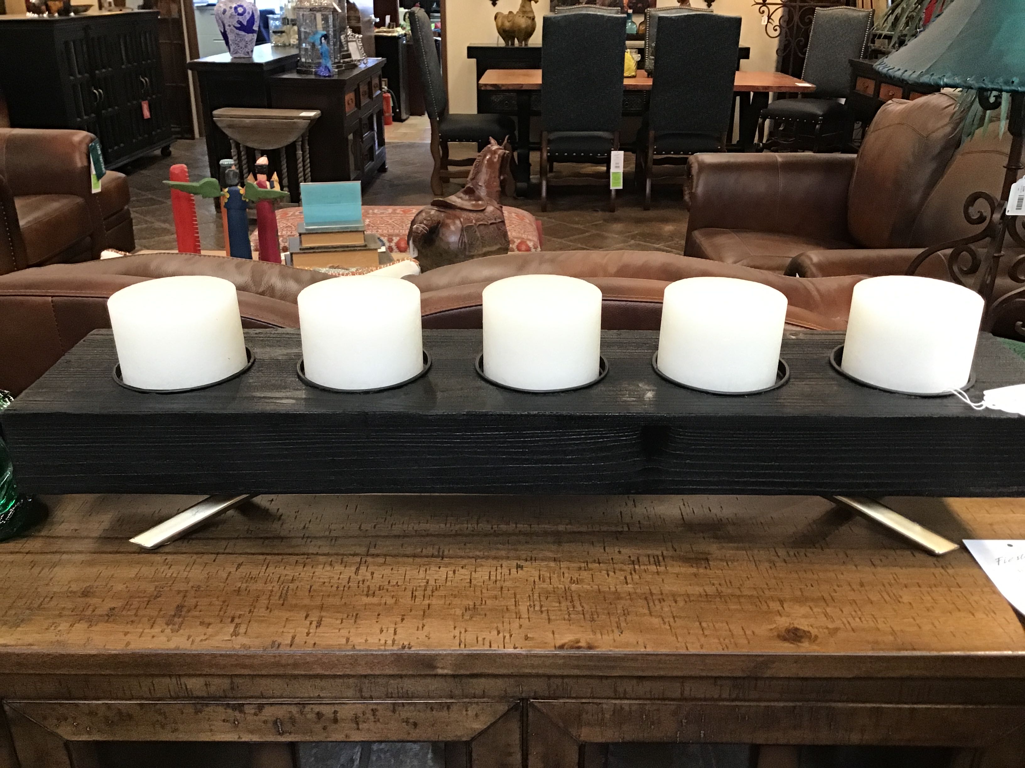 Candles on a wooden table with a blurred background of chairs and tables.