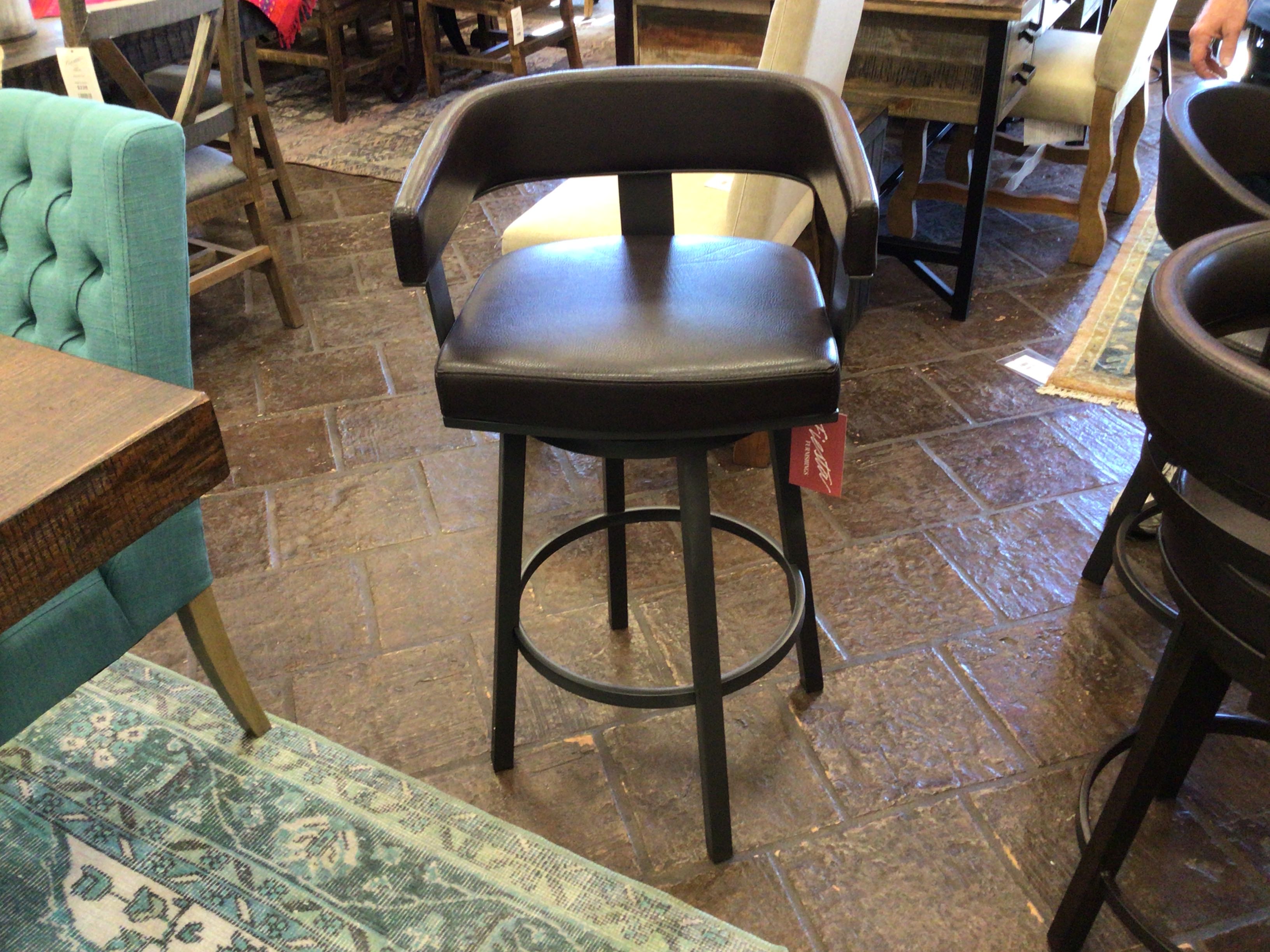Black bar stool in a casual dining setting with tables and chairs.