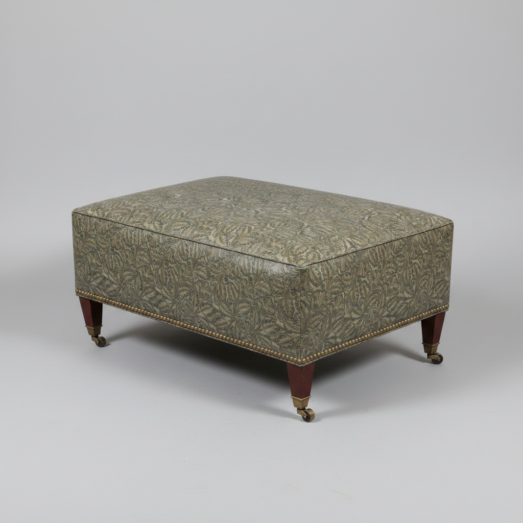 Patterned ottoman with wooden legs on a gray background