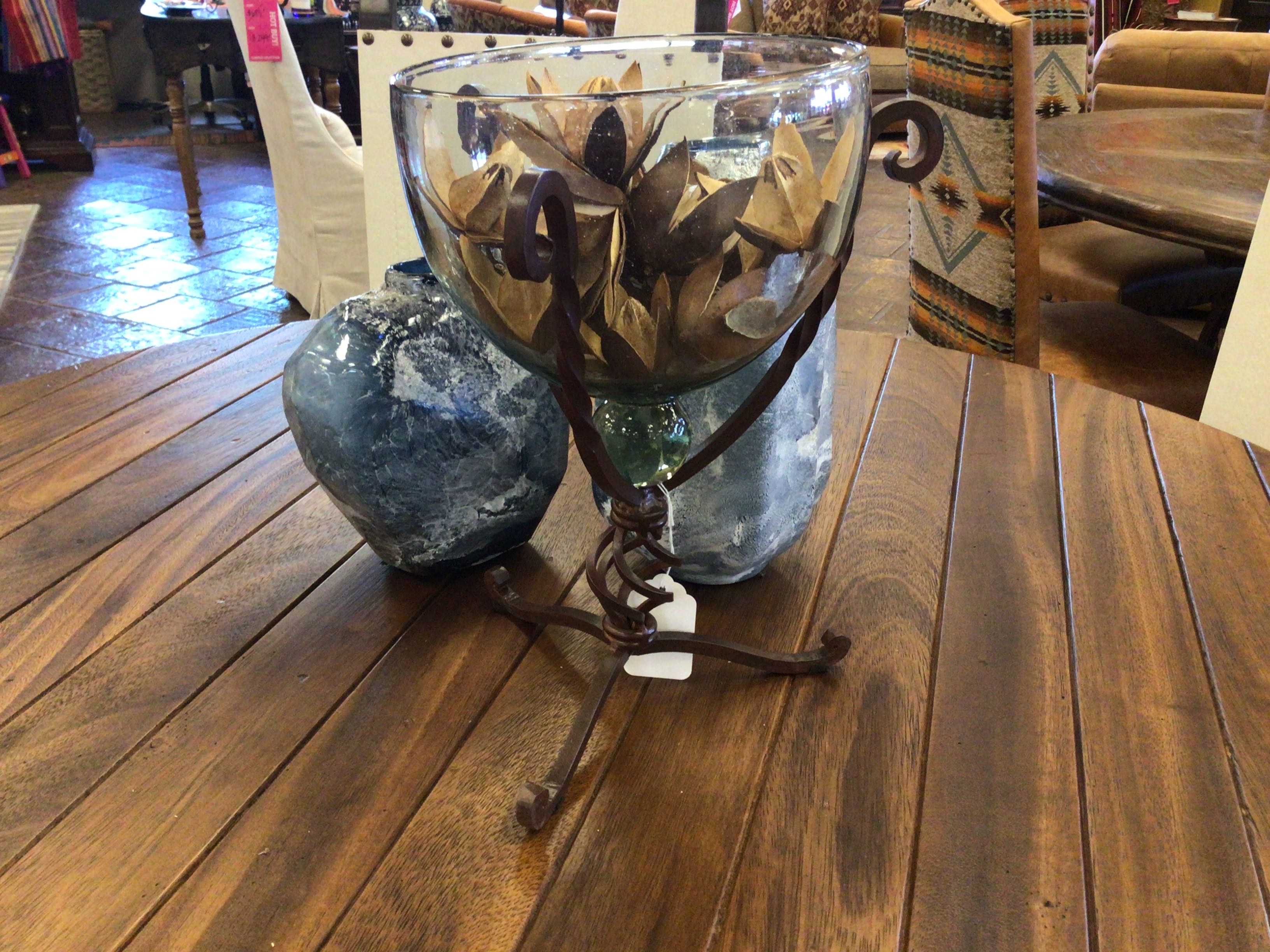 Decorative glass bowl with metal stand on a wooden table