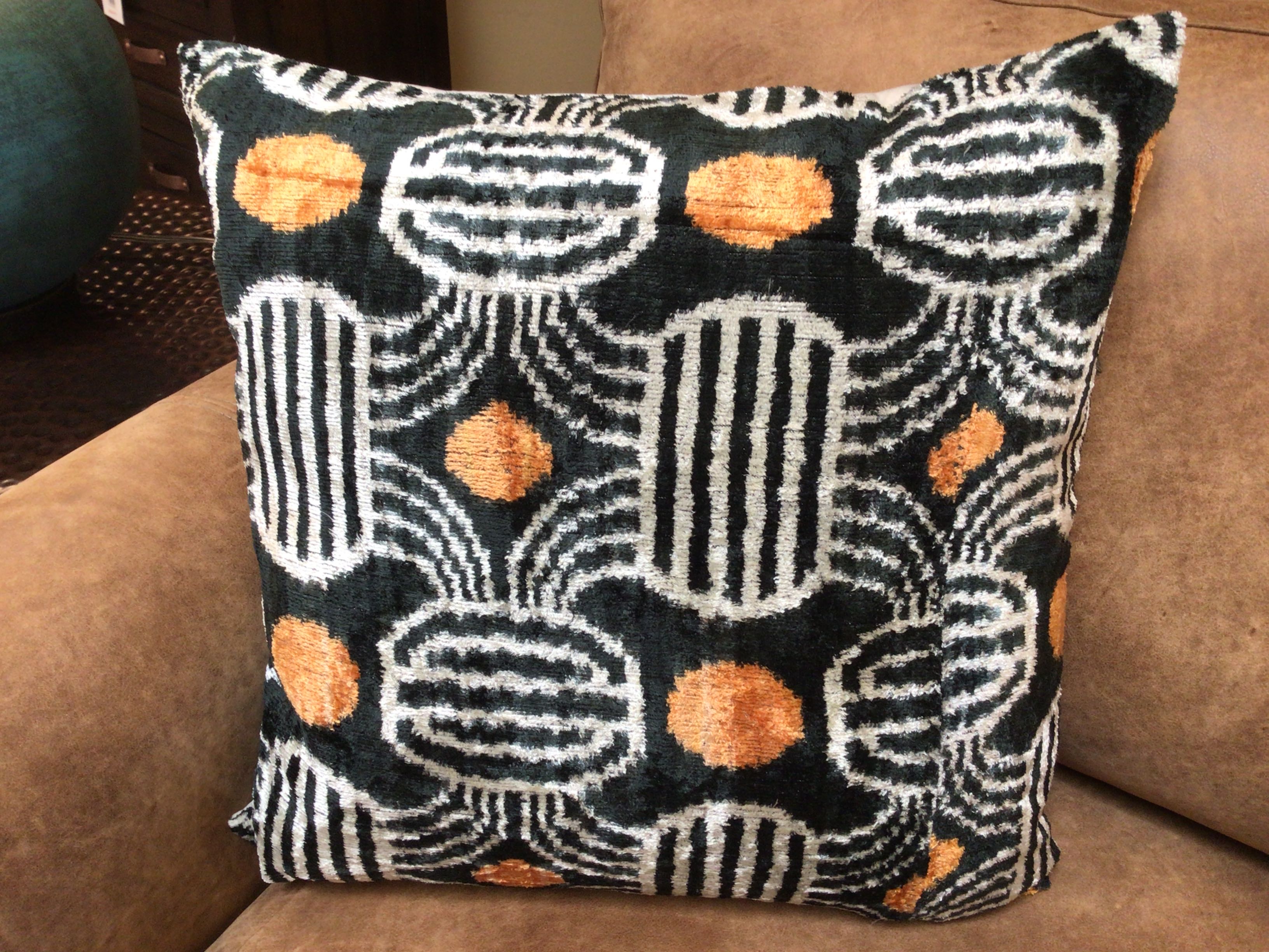 Decorative pillow with geometric pattern on a brown couch