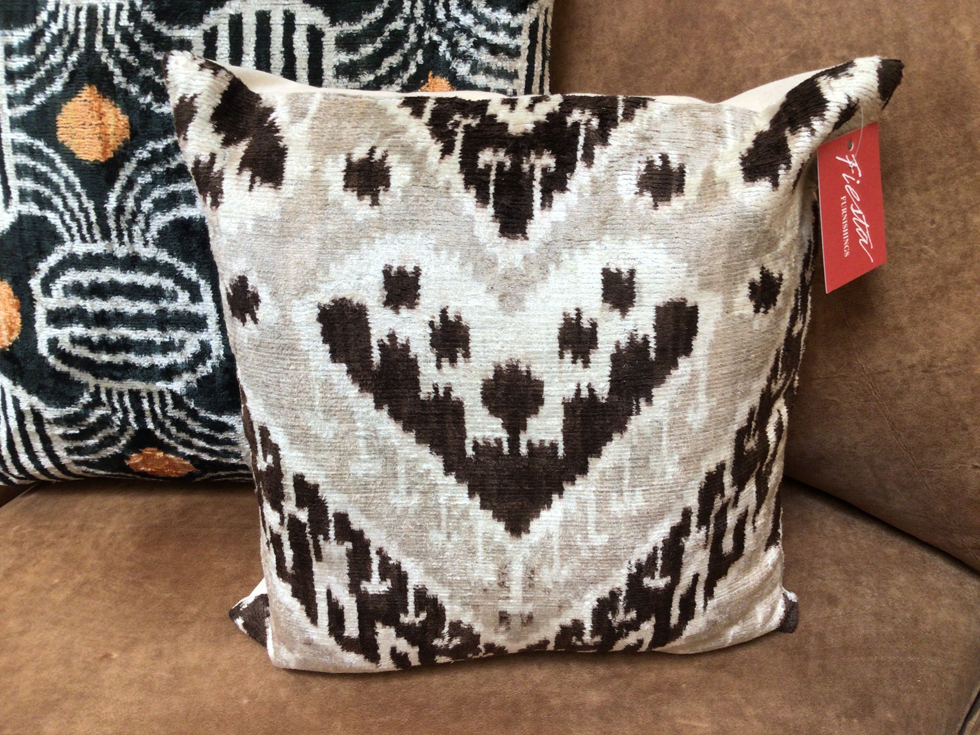 Patterned pillow with a visible tag on a brown surface