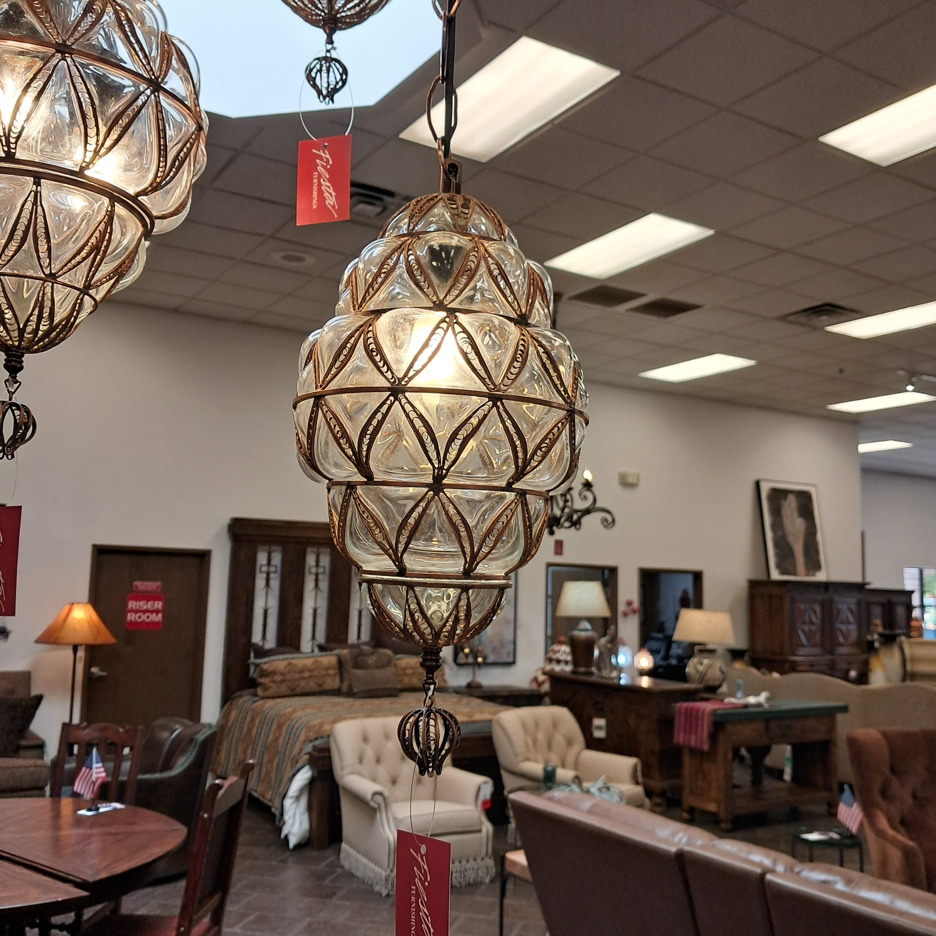 Decorative ceiling light fixture in a store setting with 'Fiora' branding.
