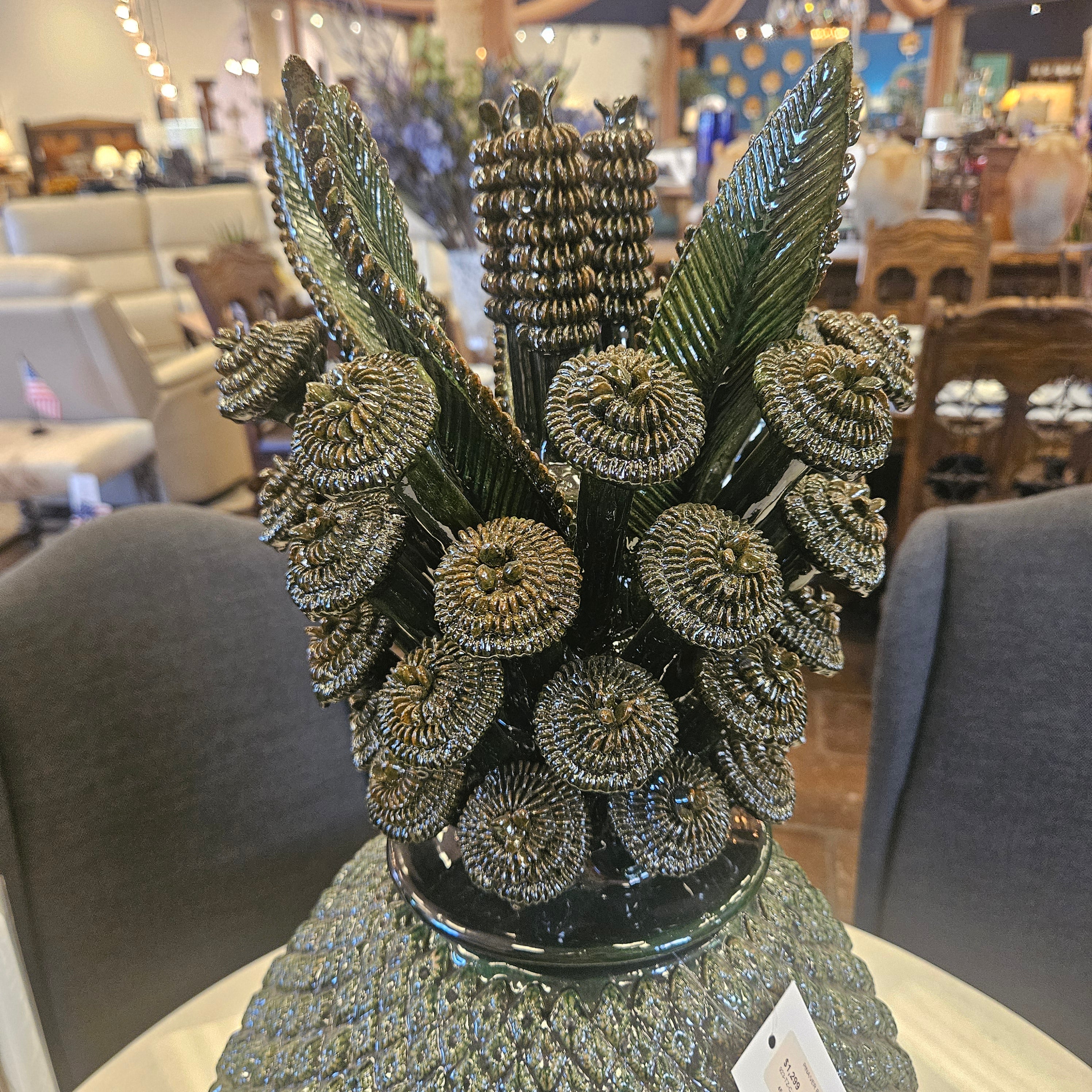 Decorative green bouquet with pinecone-like elements on a mannequin head.