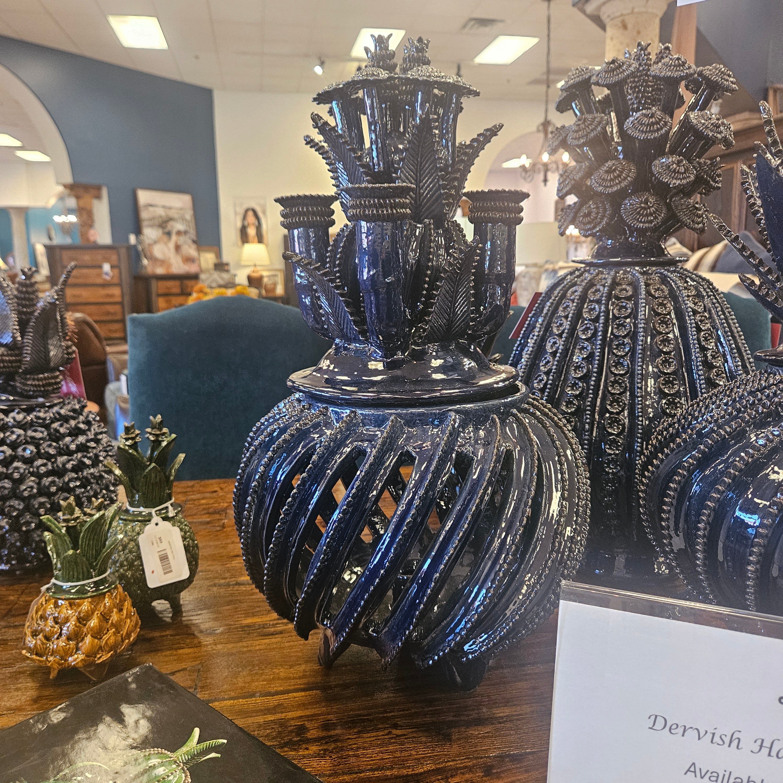 Decorative blue and black vase with intricate design on a wooden surface.