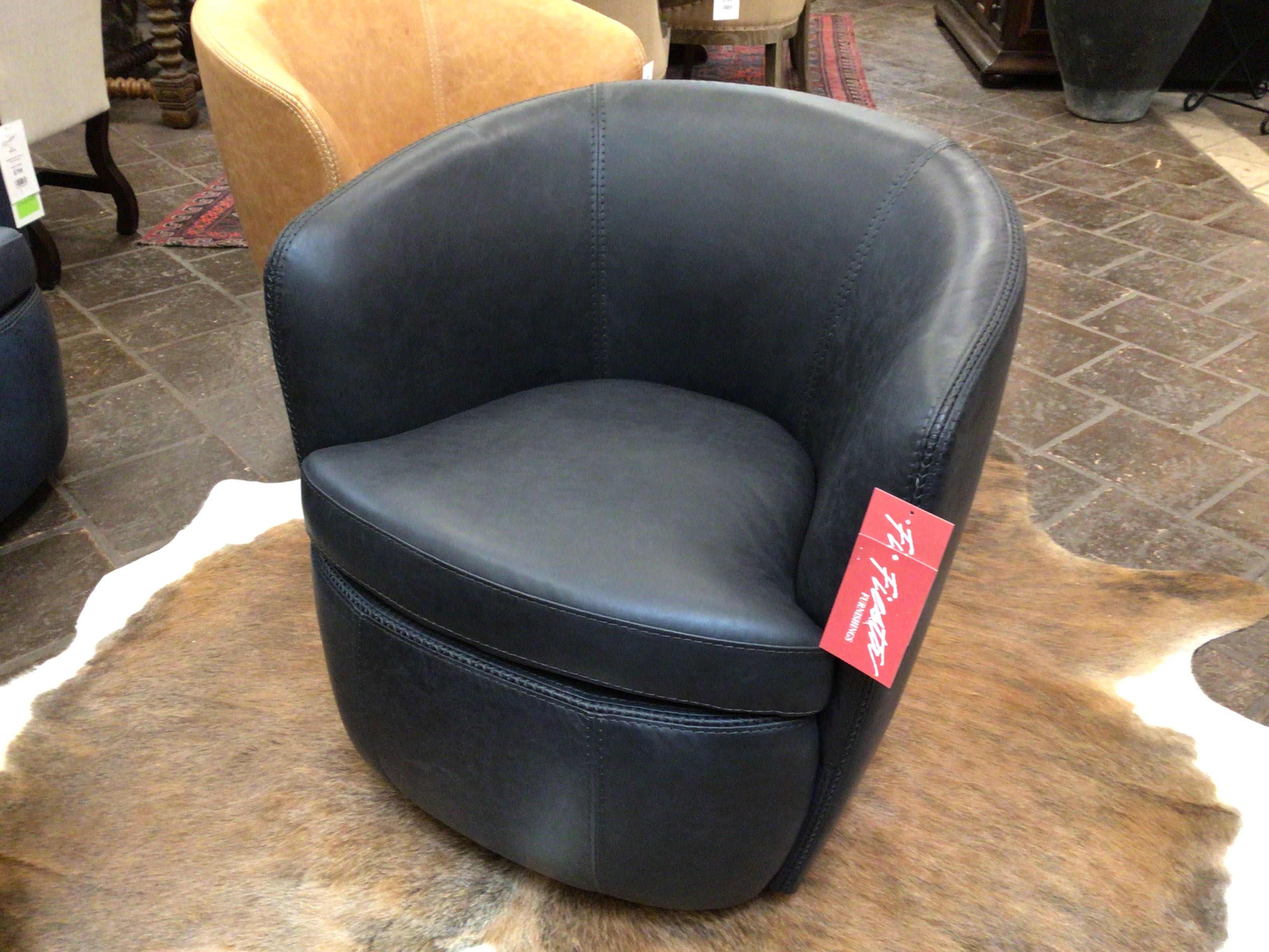 Navy leather chair with a red tag on a textured floor