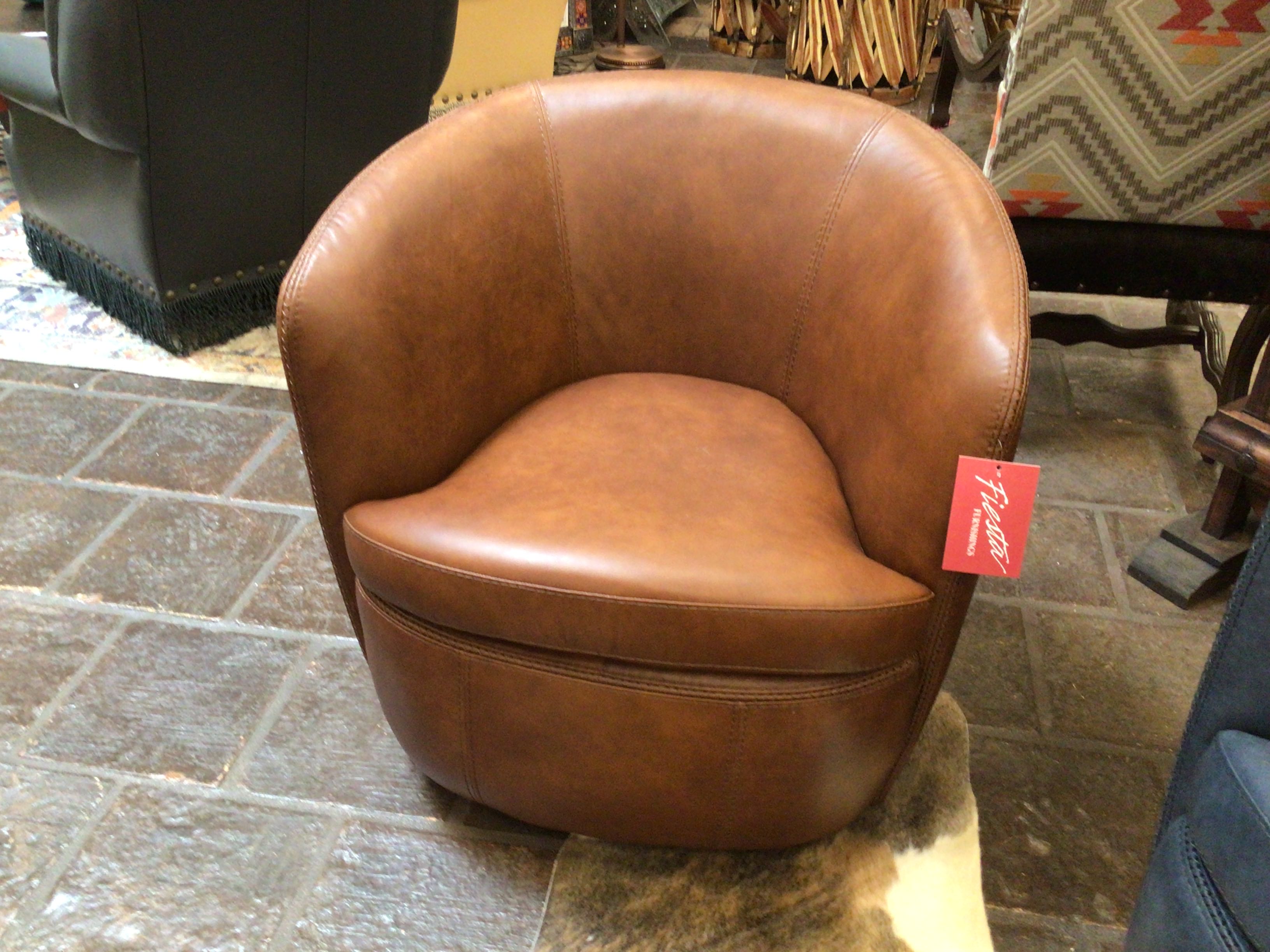 Brown leather chair with a red tag on a stone floor