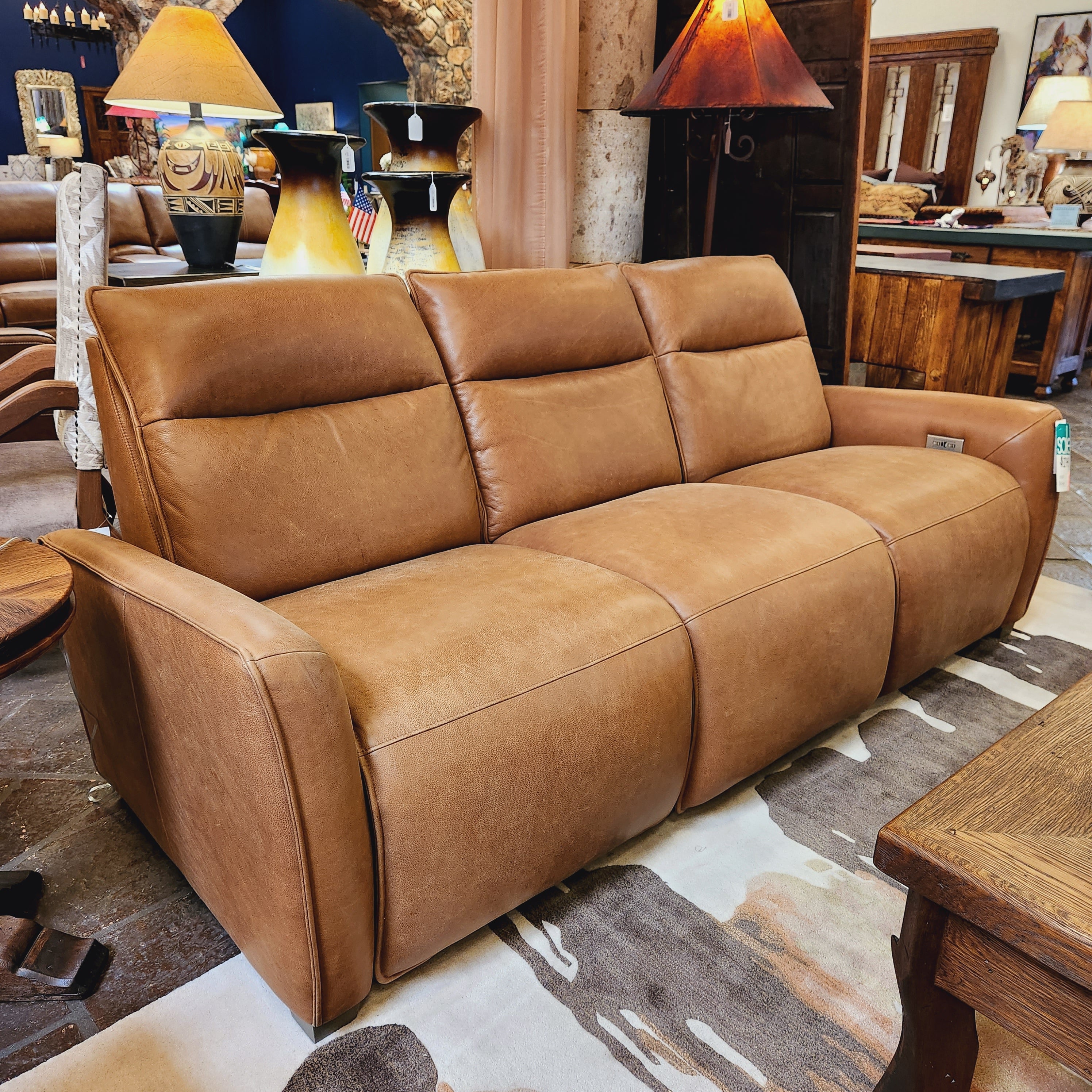 Brown leather sofa in a room with wooden furniture and decor.