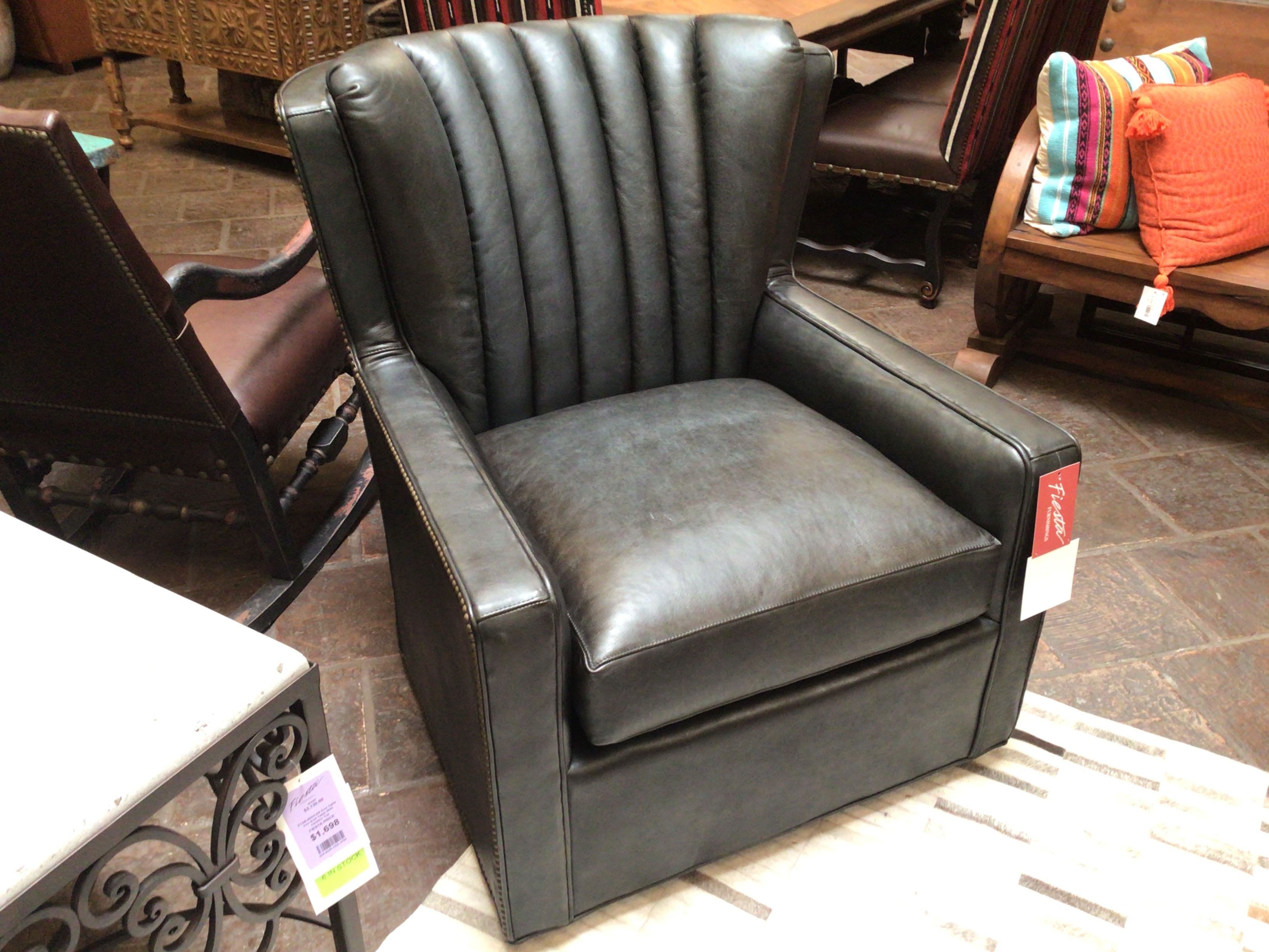 Black leather armchair in a showroom setting with price tags.