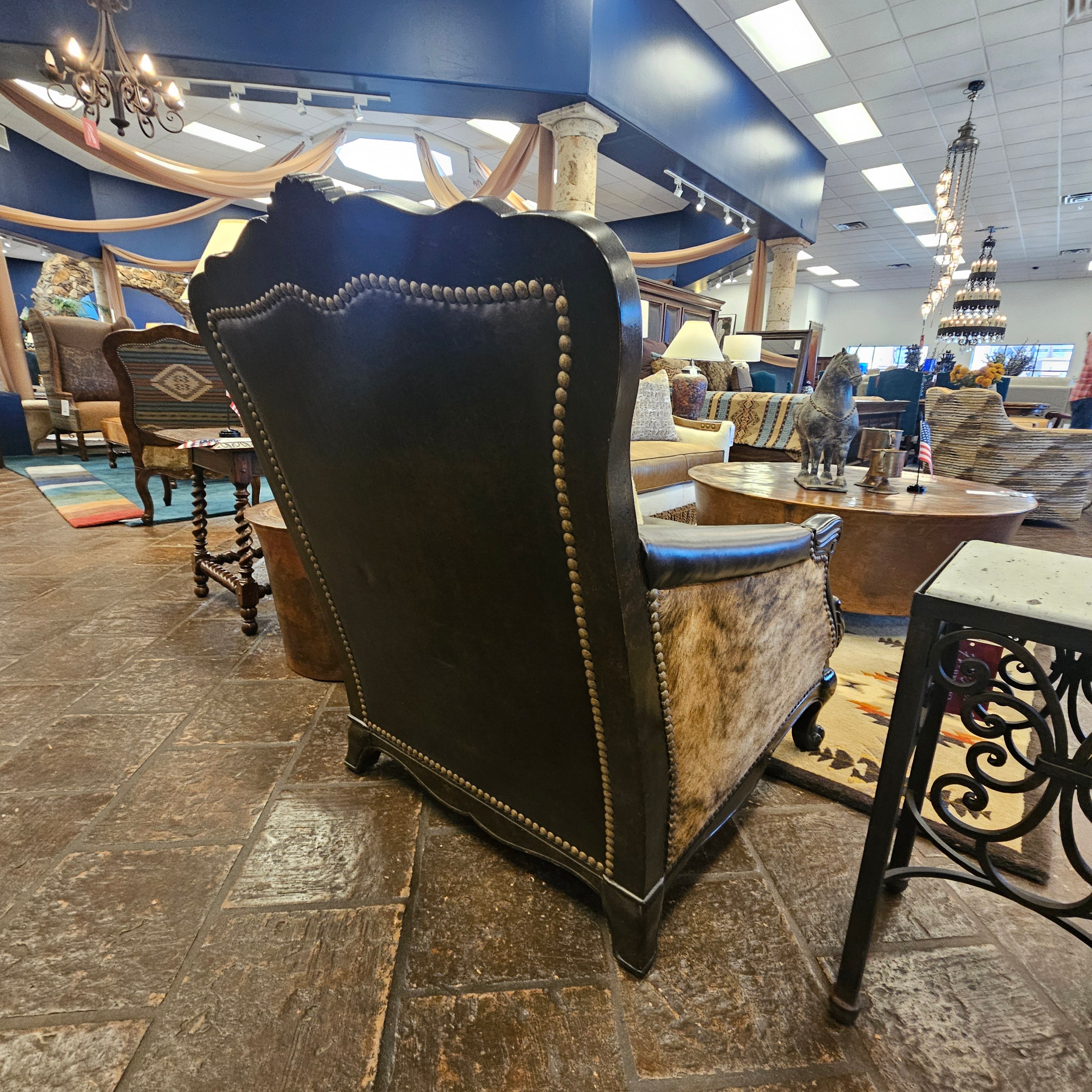 Decorative chair with intricate design in a room with stone walls and large windows.