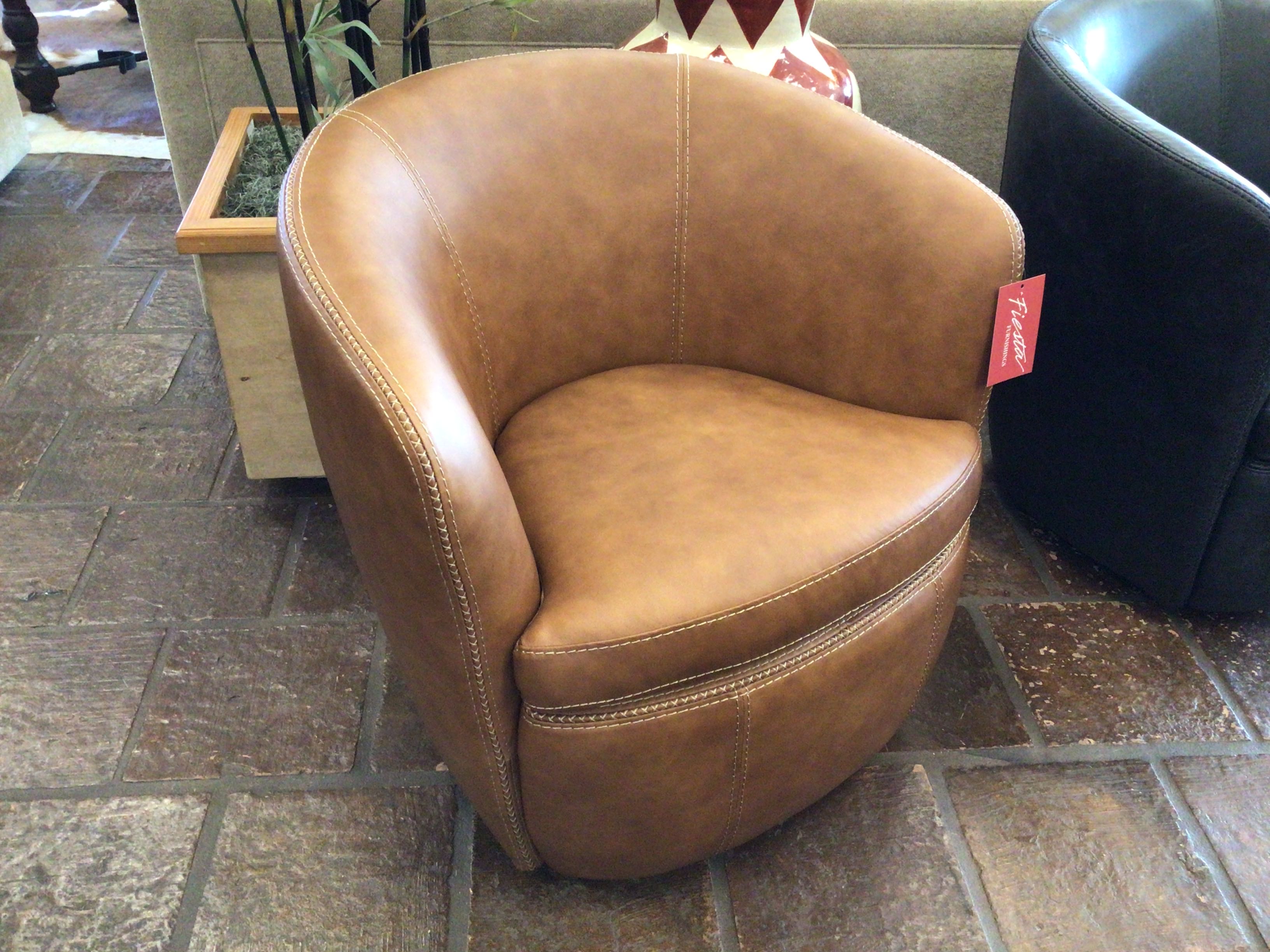 Brown leather chair on a stone floor with a visible brand tag.