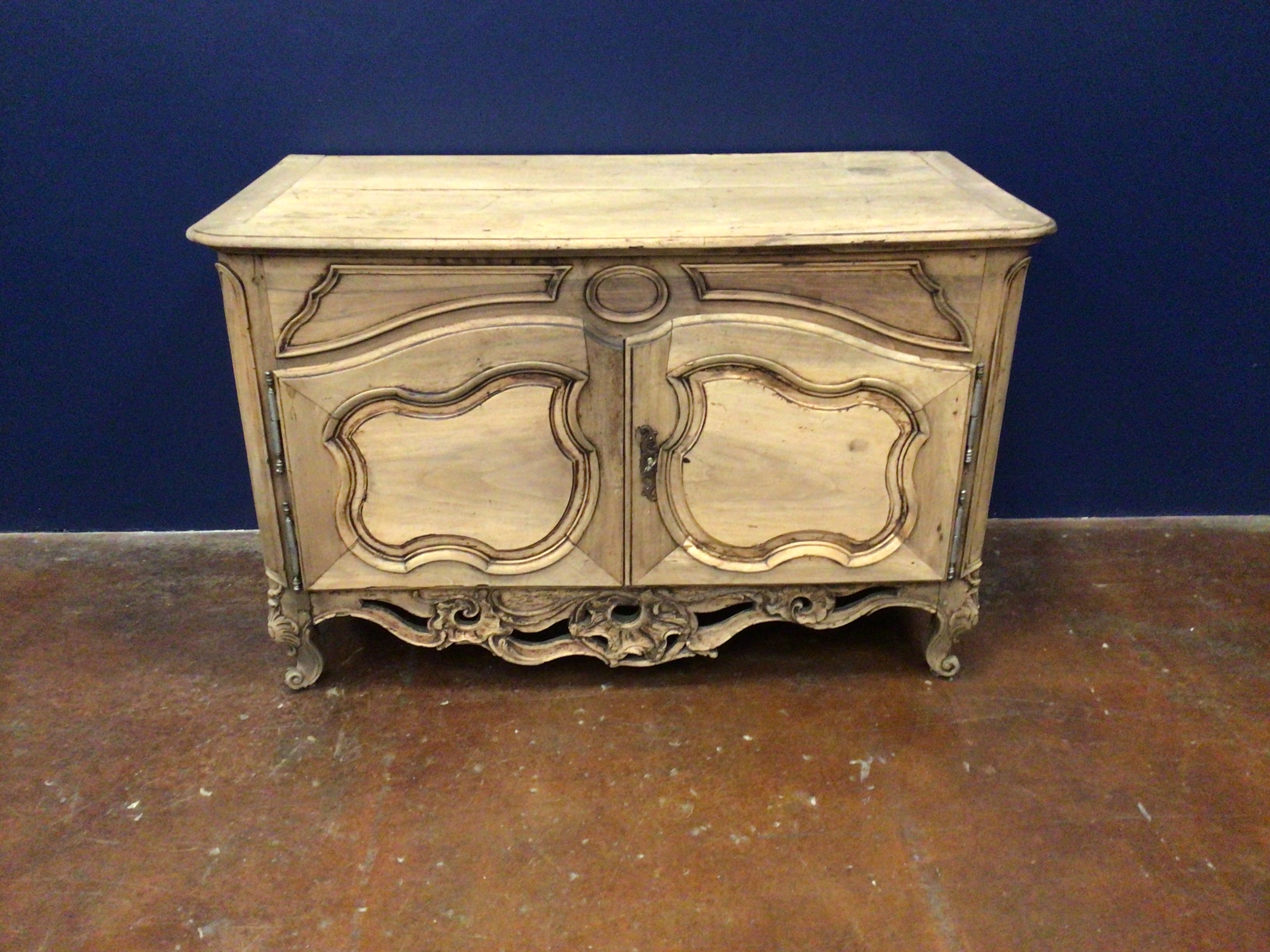 Vintage wooden chest with marble top against a blue wall.