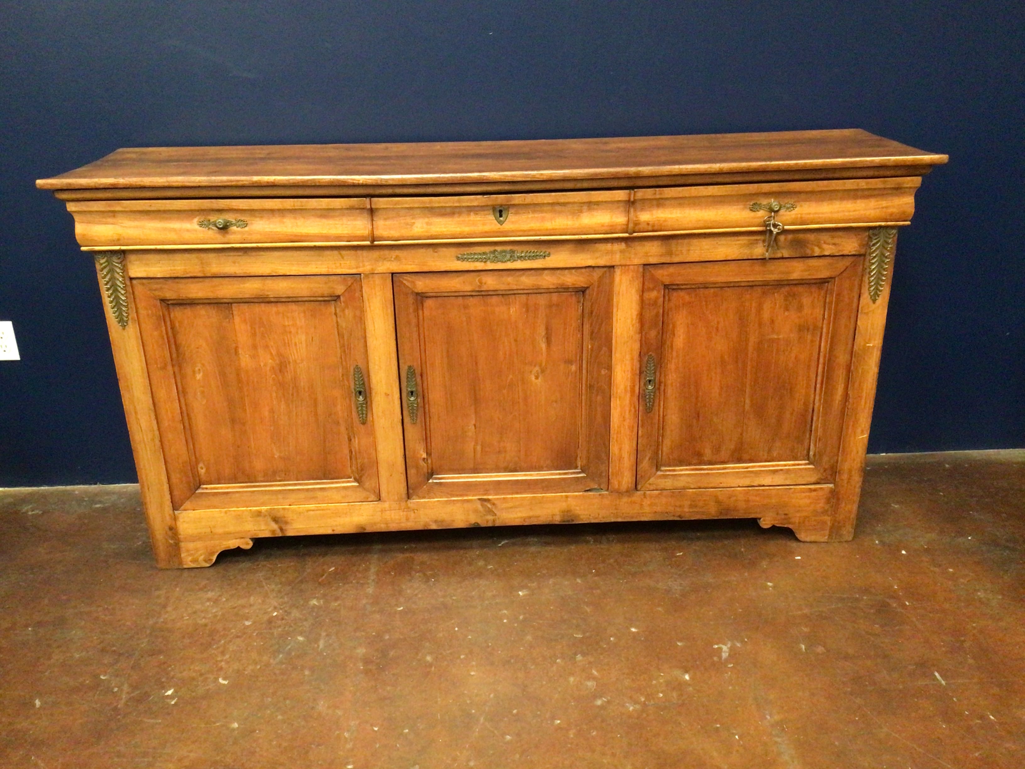 Wooden sideboard with decorative elements against a blue wall