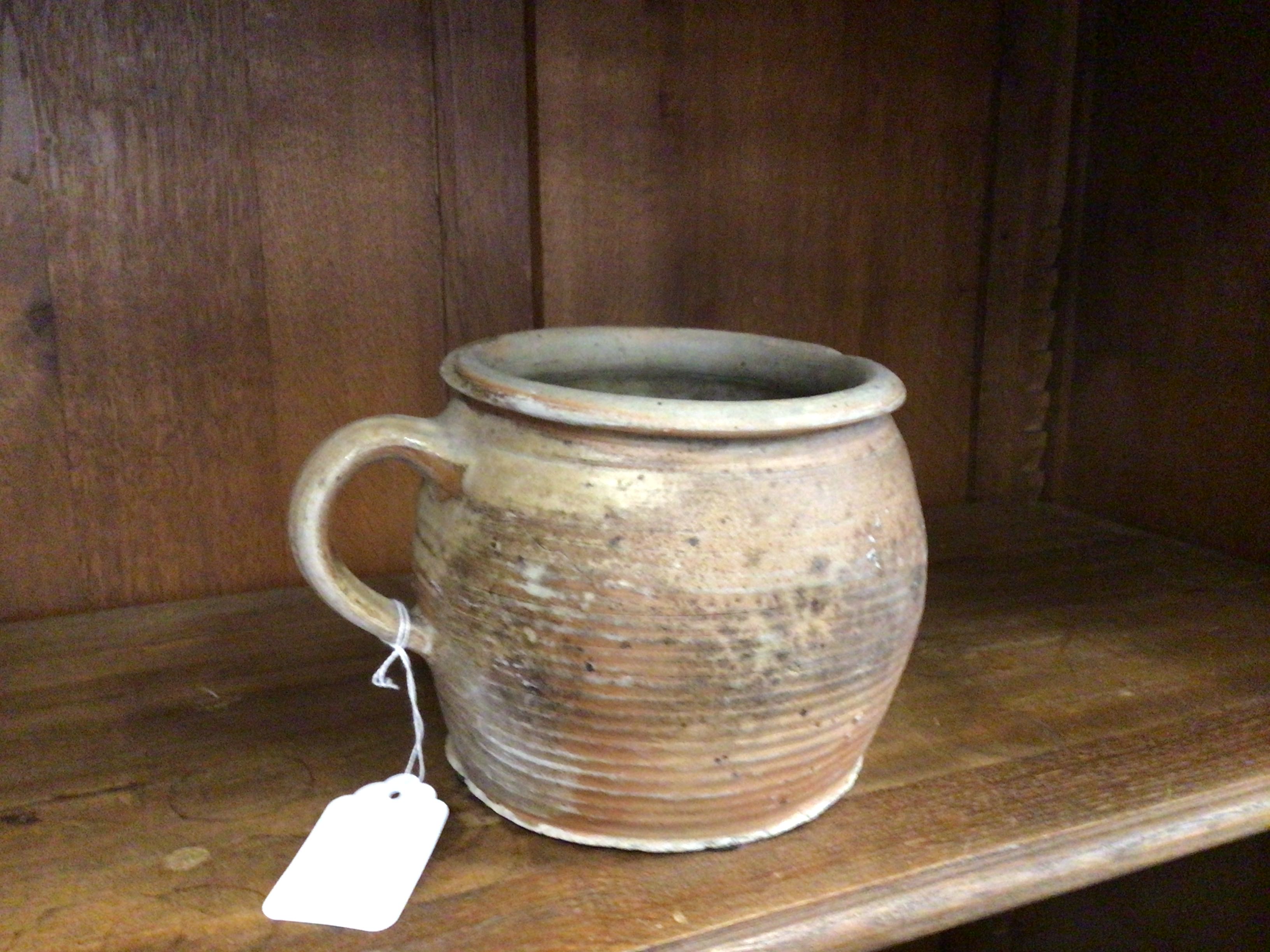 Ceramic mug with a tag on a wooden surface against a wooden panel background