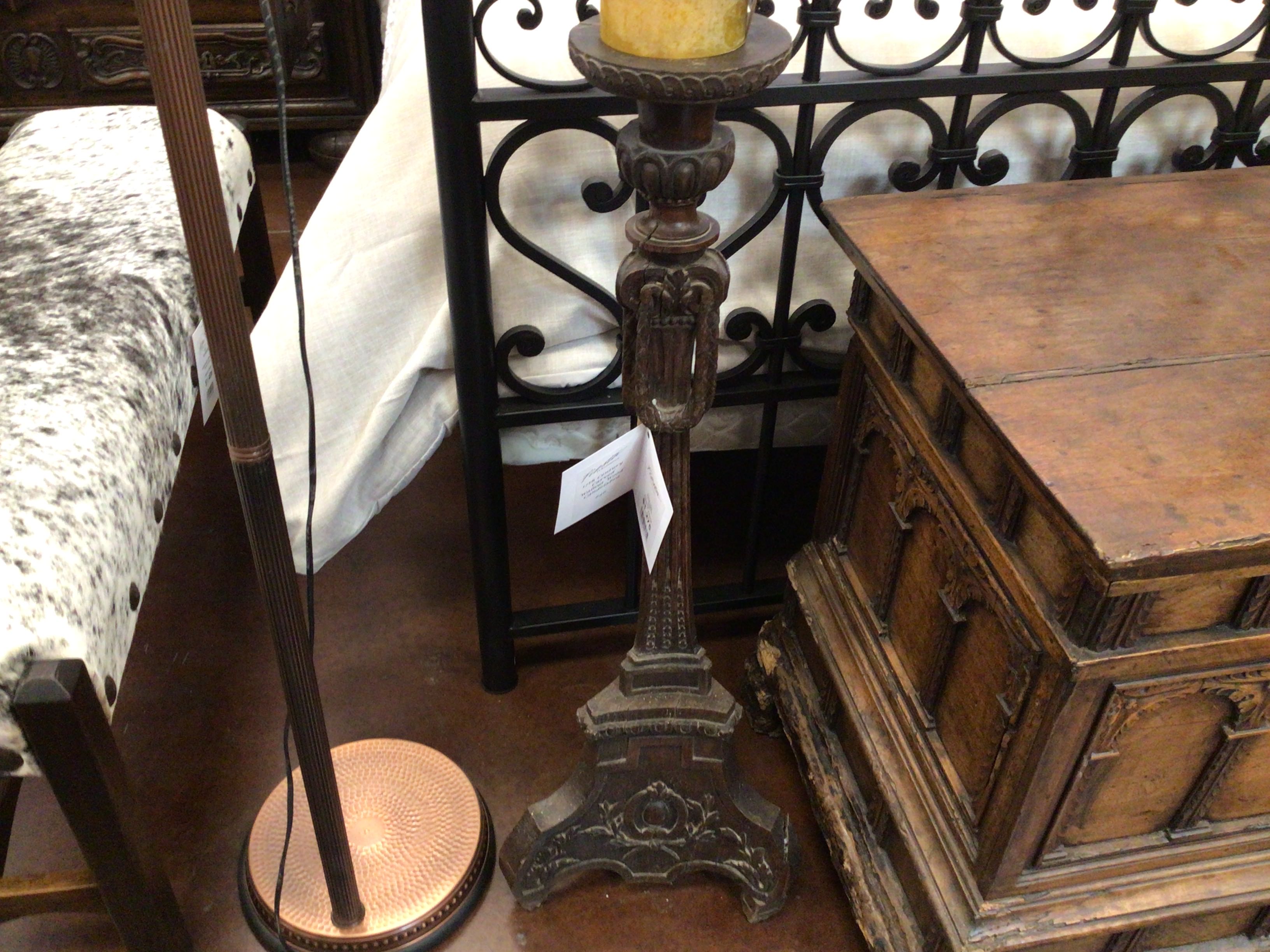 Decorative candle holder with a wooden chest and chair in the background